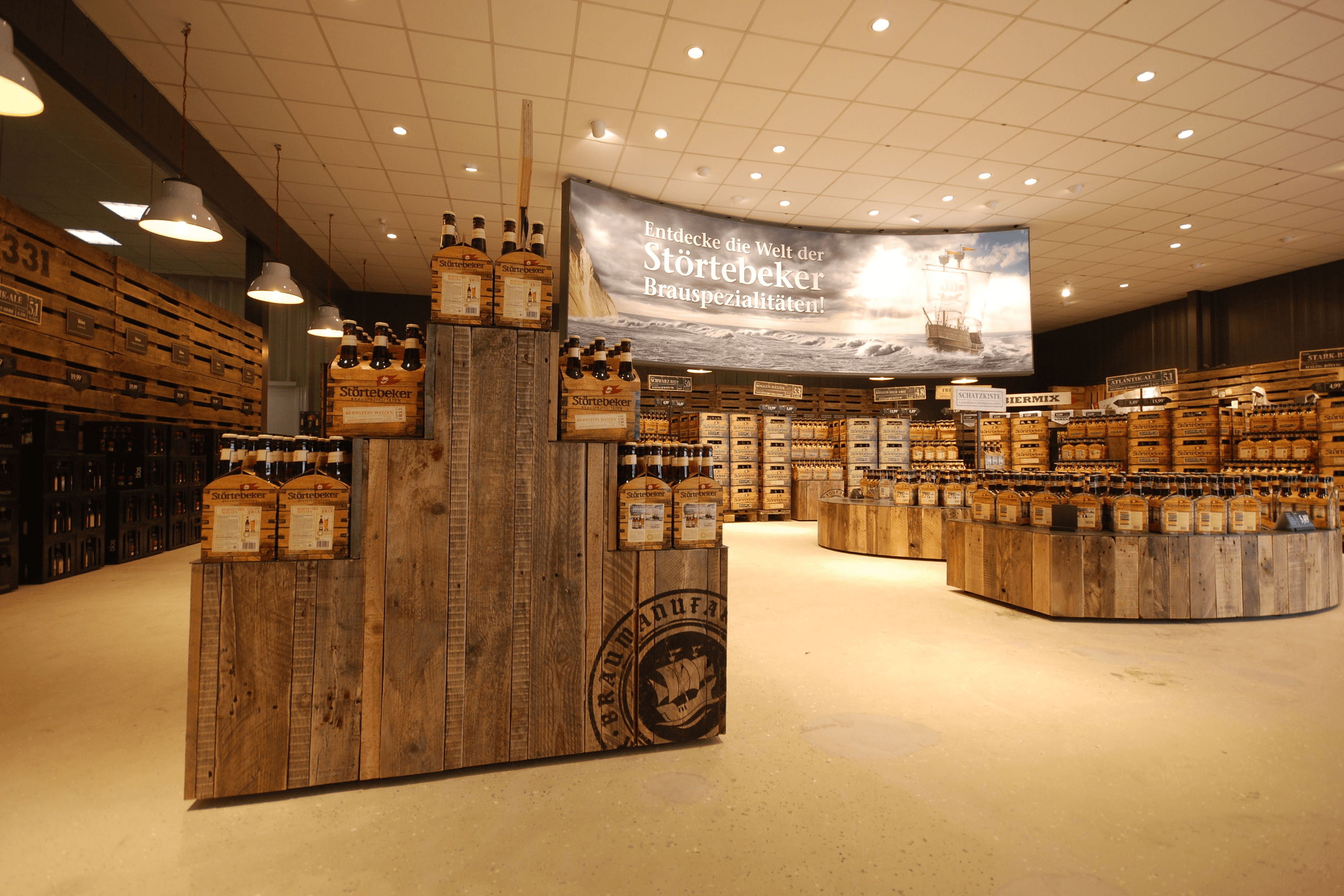 Beer bottles displayed in a store with wooden crates and signage.