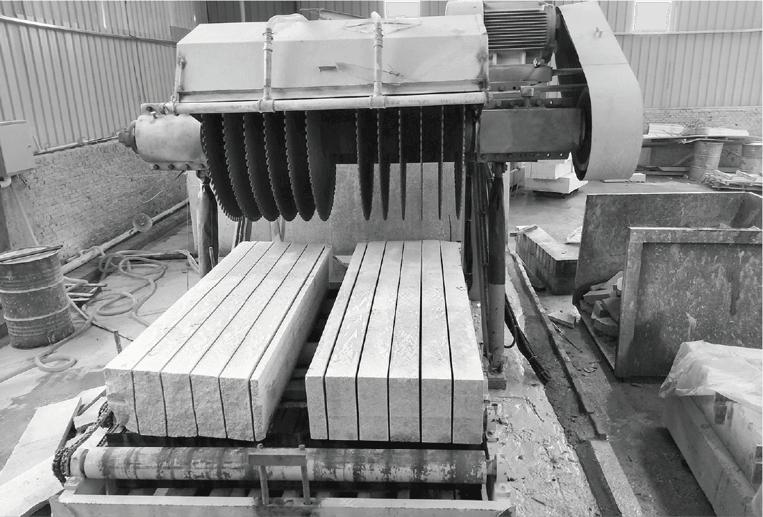 Dinosaw Kerbstone Cutting Machine in action, showcasing its precision in cutting large stone blocks with multiple blades simultaneously.