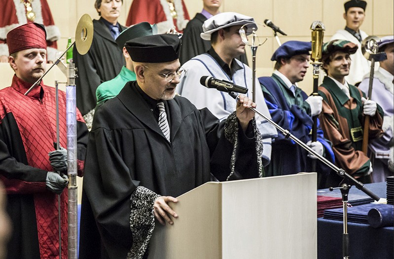 a man in a black robe is giving a speech