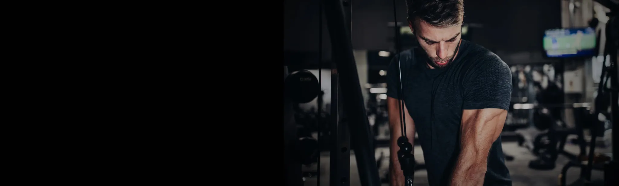 A man training on a cable machine in a high-performance gym featuring Core Fitness USA