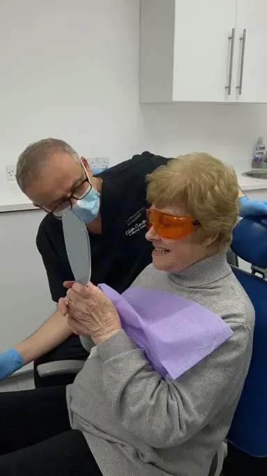 Dr Yasser and his patient looking in the mirror and speaking about the patient's teeth