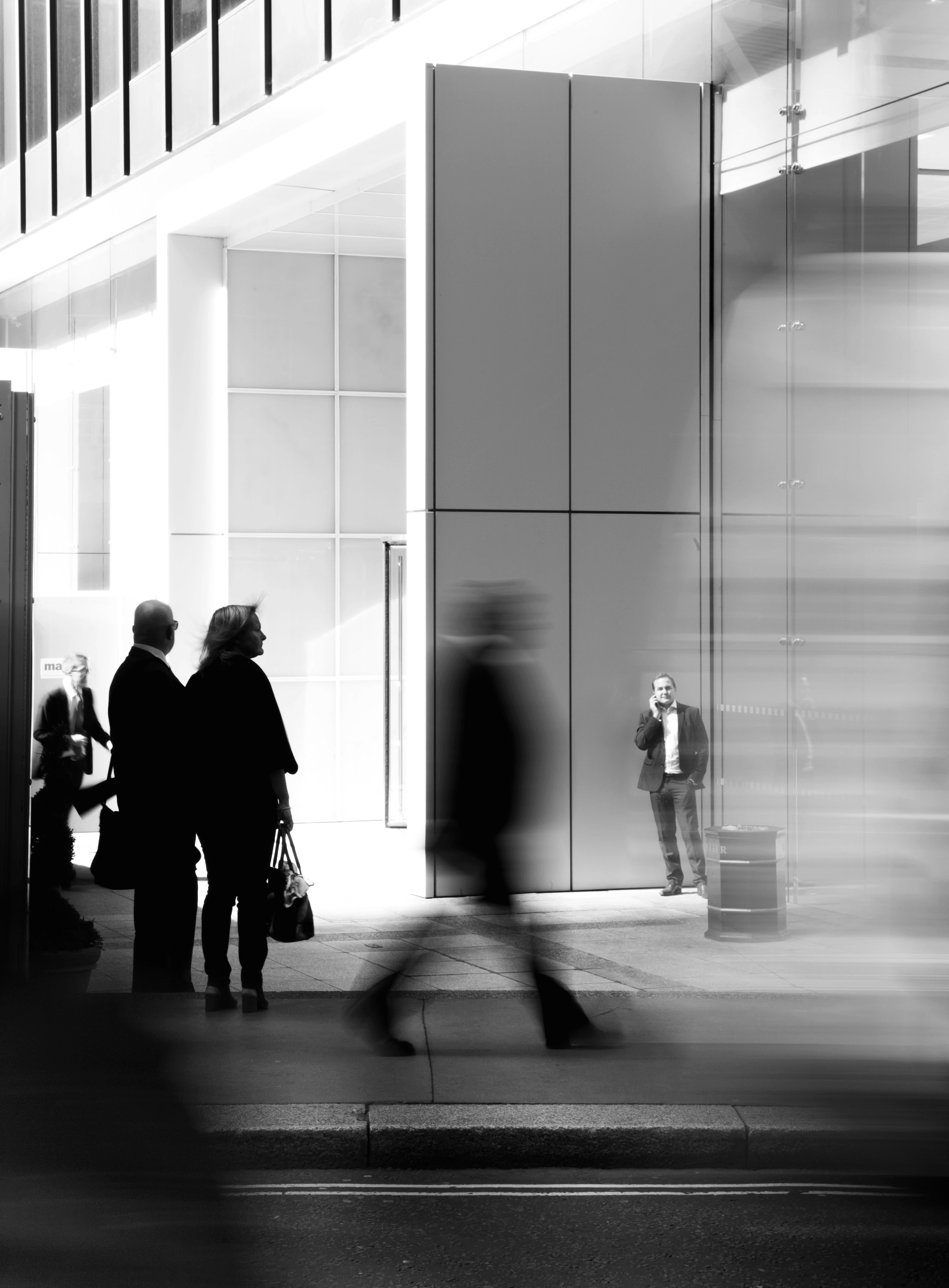 grayscale photo of people walking towards building