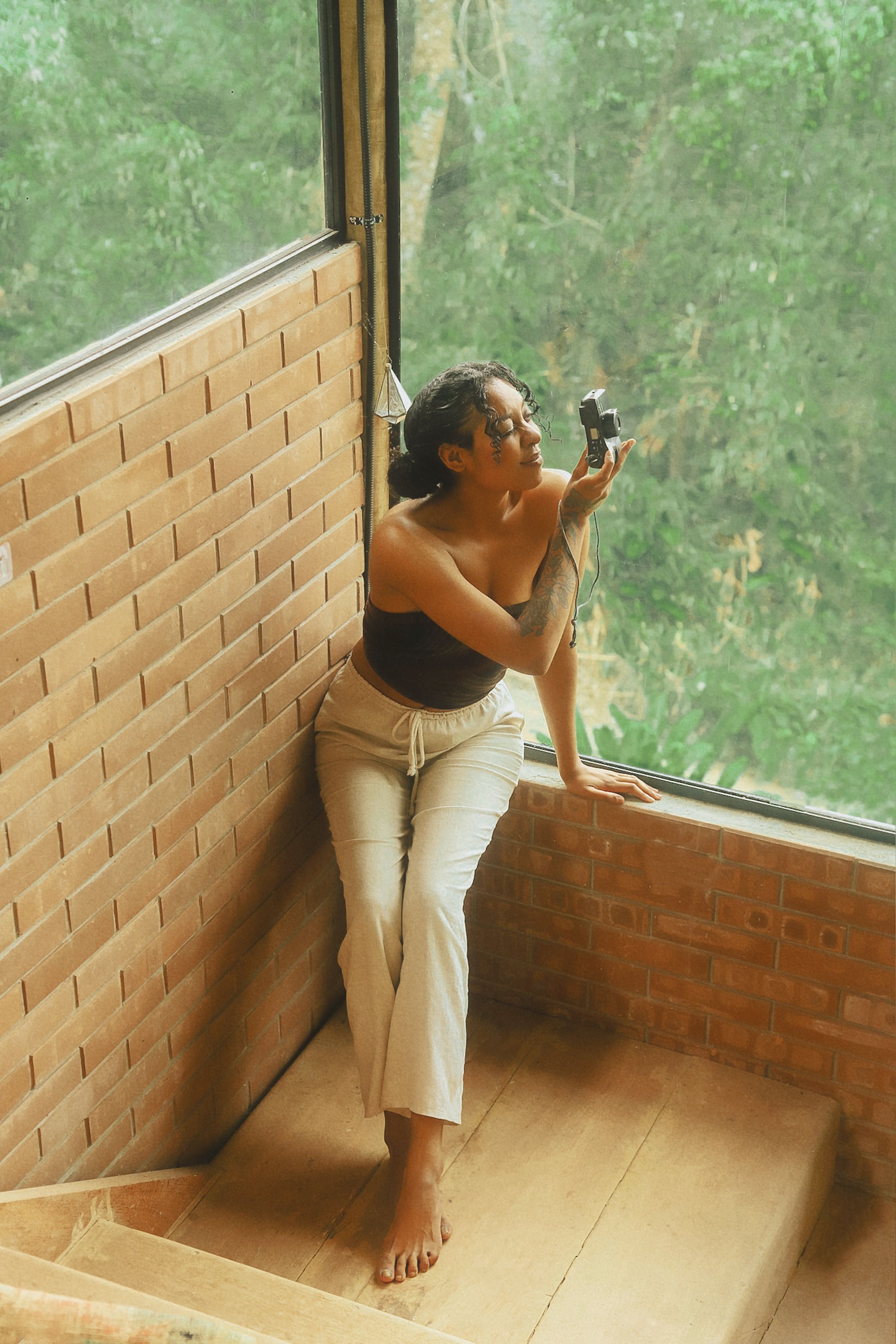 Woman taking a selfie while sitting on wall
