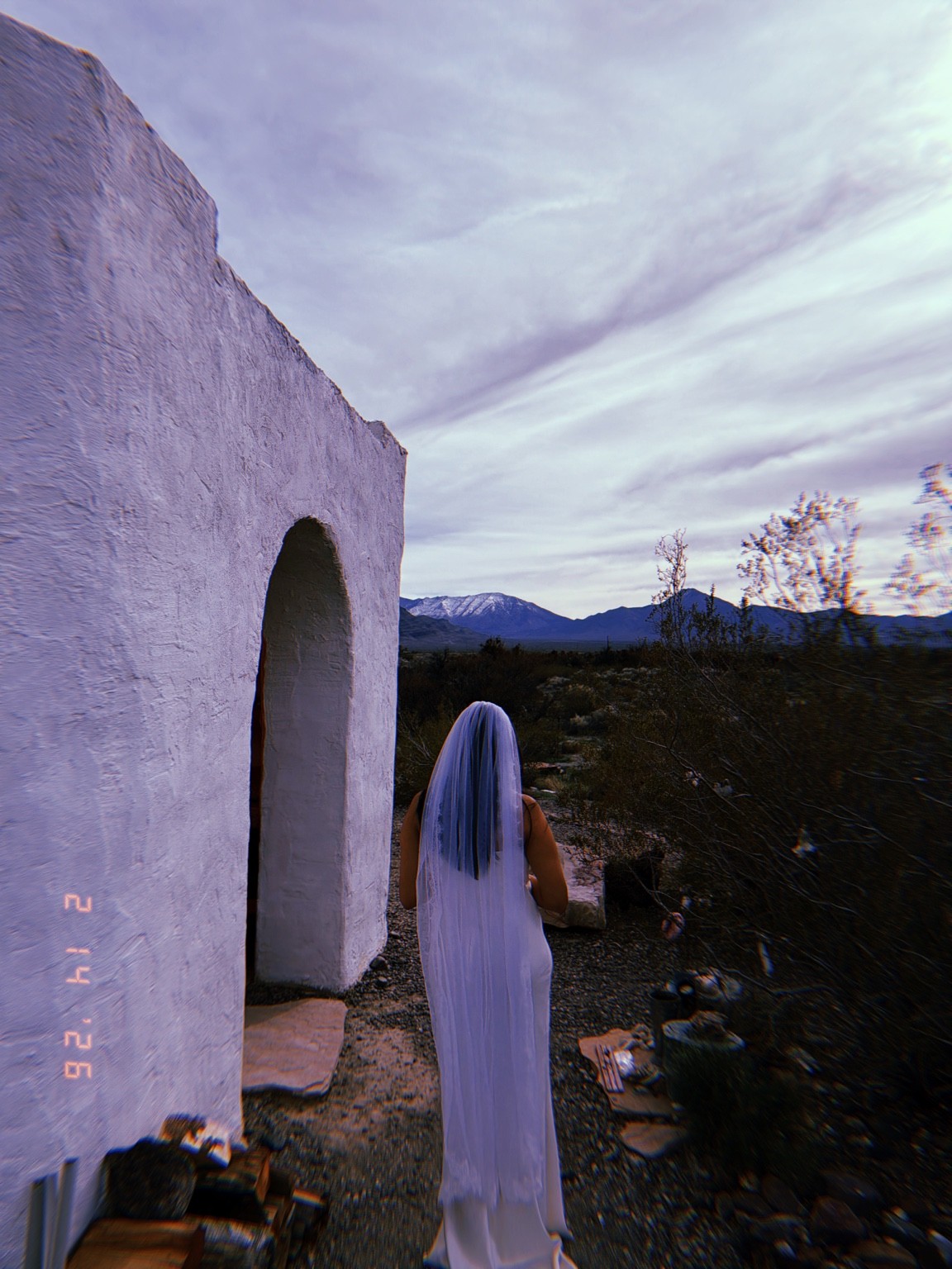 A veiled figure beside a white arch Photograph by Pranjali Shah.