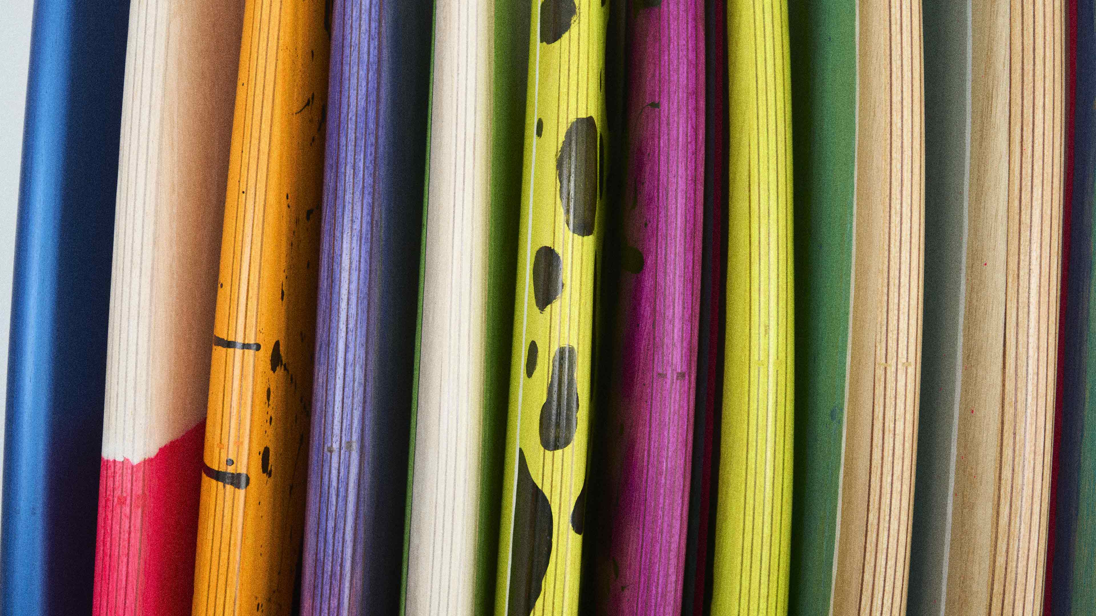 Various colourful wooden surfboards stacked together