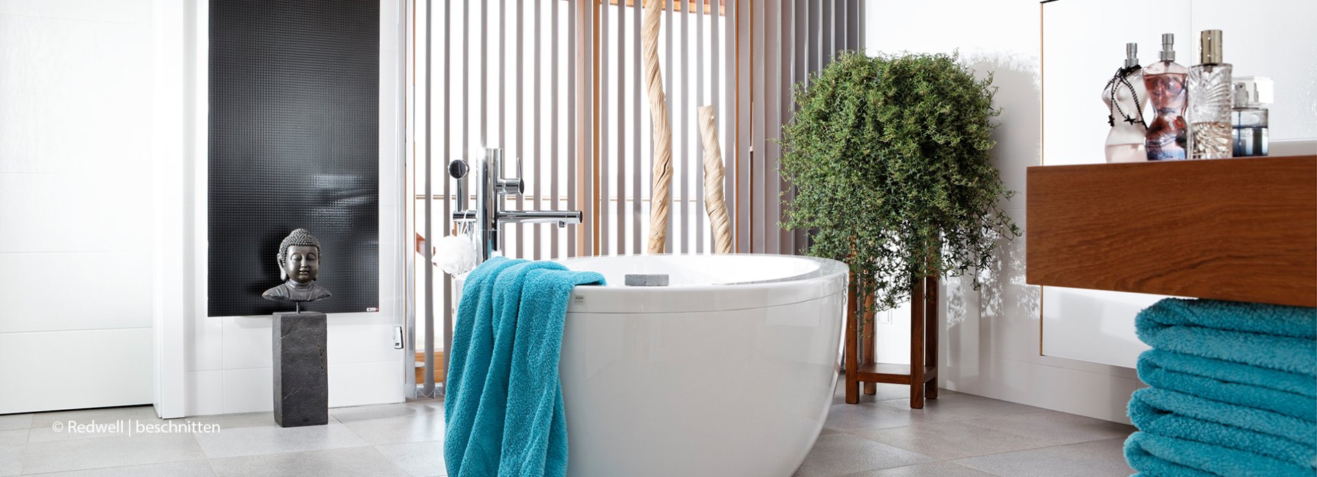 Modernes Badezimmer mit Badewanne, Türkisen Handtüchern, Pflanzen und minimalistischer Einrichtung. Wellness Oase.