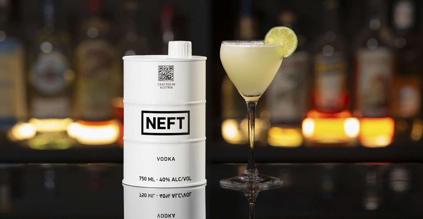 A NEFT Barrel and a glass of Key Lime Pie Martini on a bar counter.