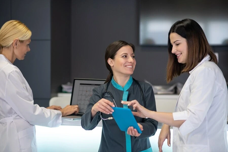 female-doctors-smiling-while-watching-video-tablet