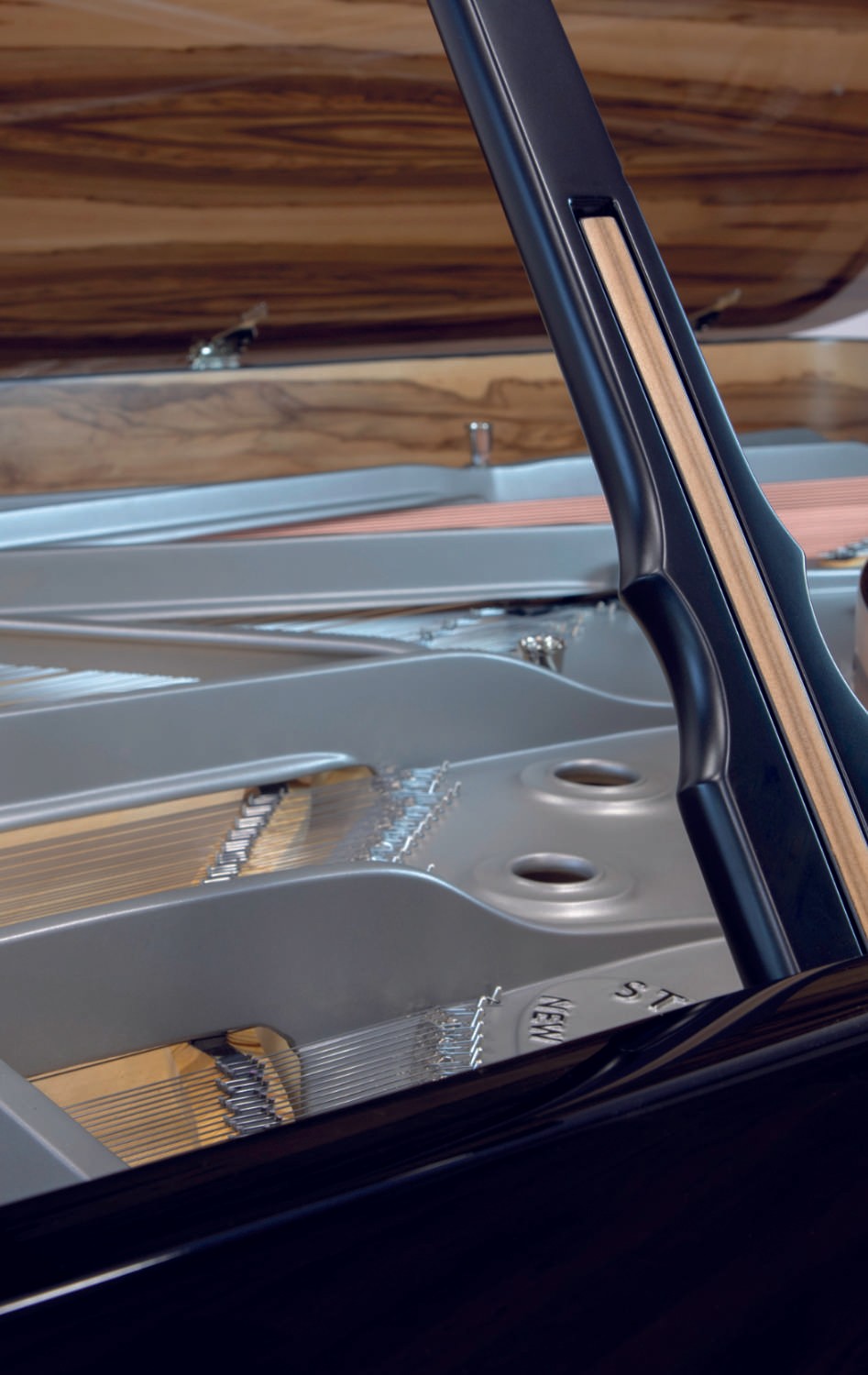 A stunning restored Steinway & Sons grand piano with a black polyester finish, amberwood elements, and a gray iron frame.