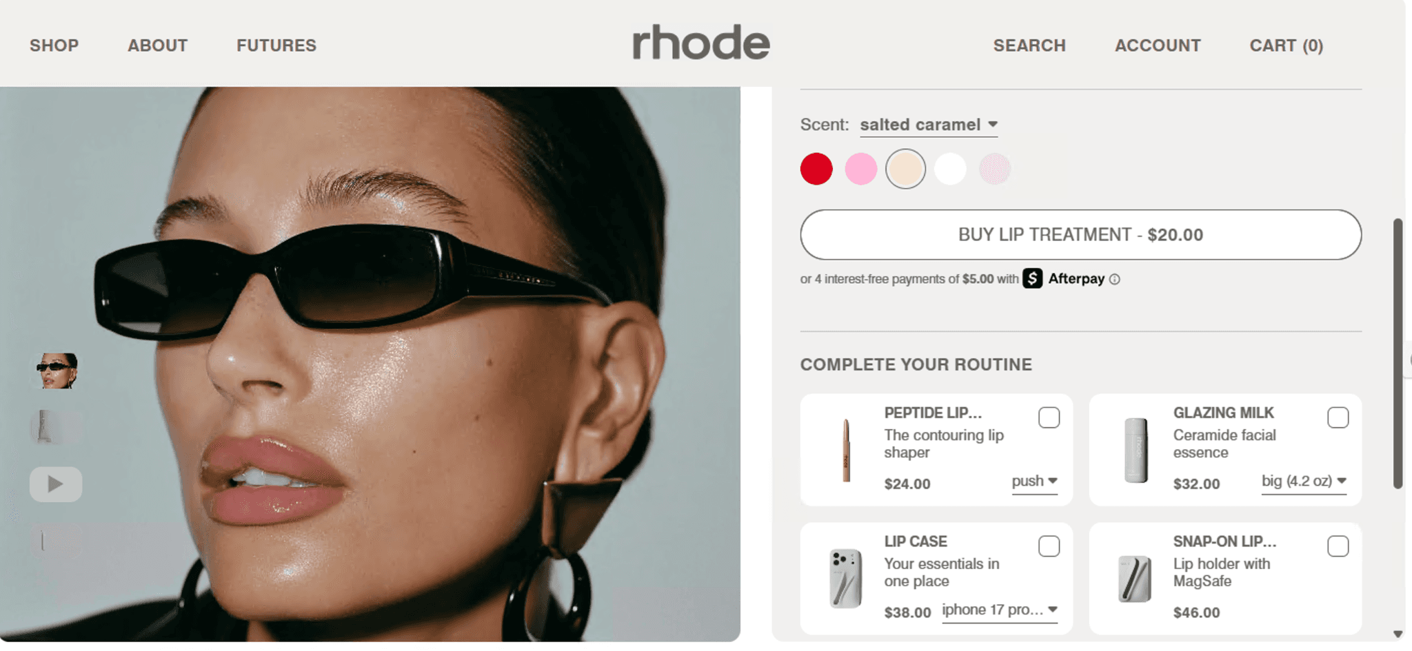 Hailey Bieber wearing Rhode Peptide Lip Treatment salted caramel and black sunglasses.