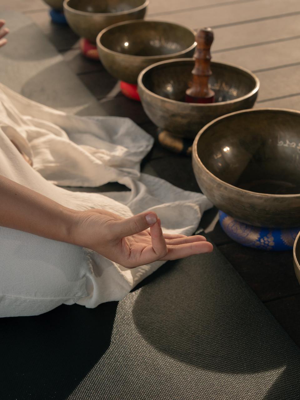 A woman in motion during a yoga session in a light-filled modern room with large windows, wood floors