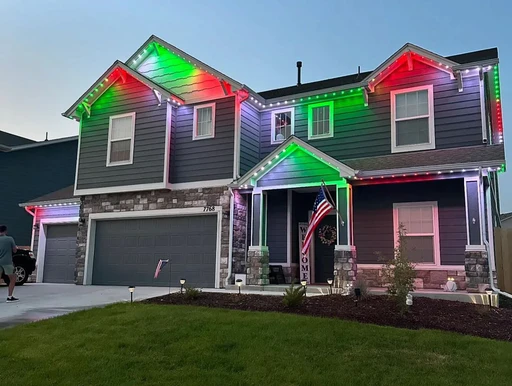 Professional Christmas light installation on a home in Chester County, PA, with roofline lights and outdoor tree decorations.