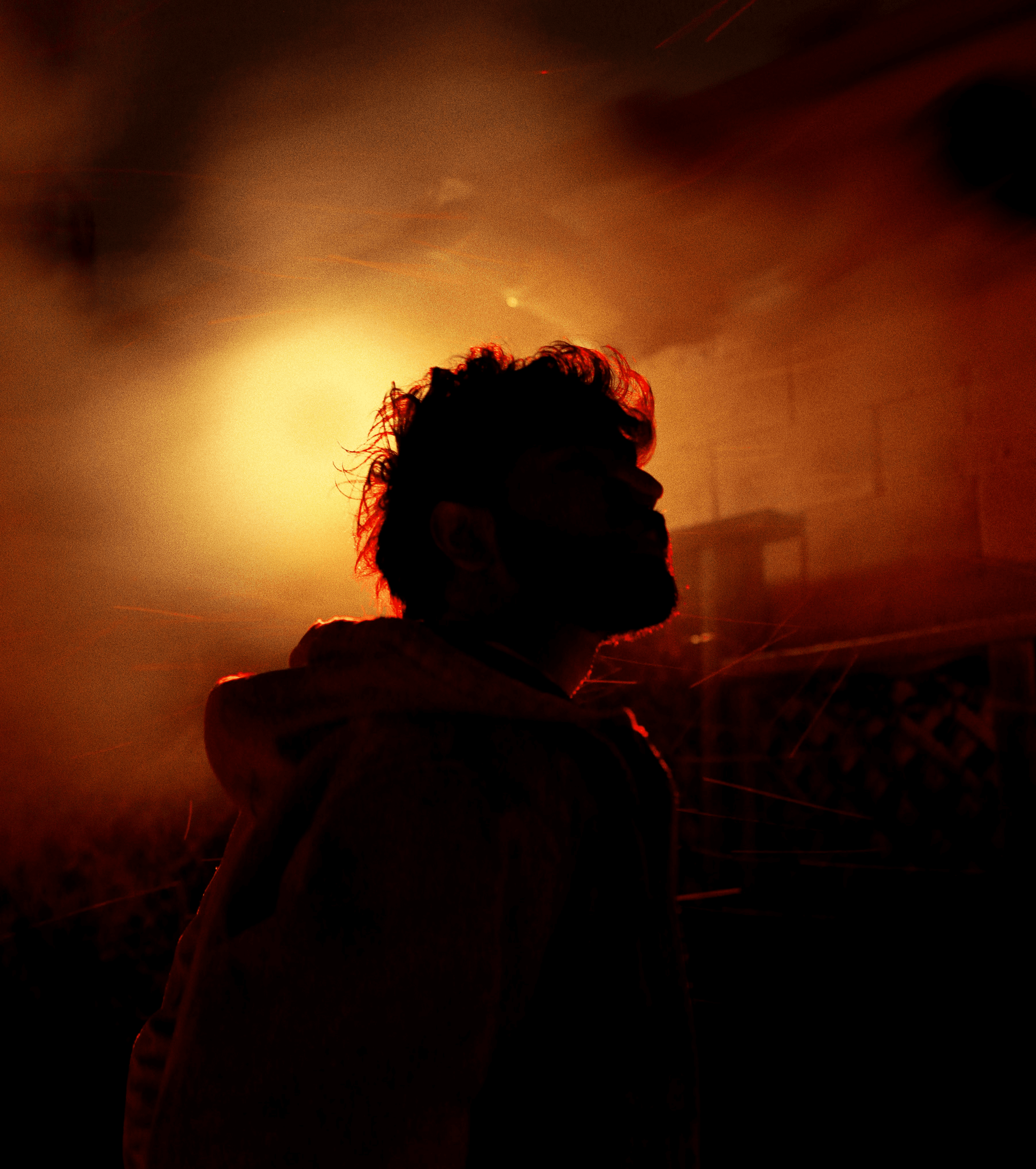 Man silhouetted against a bright orange light