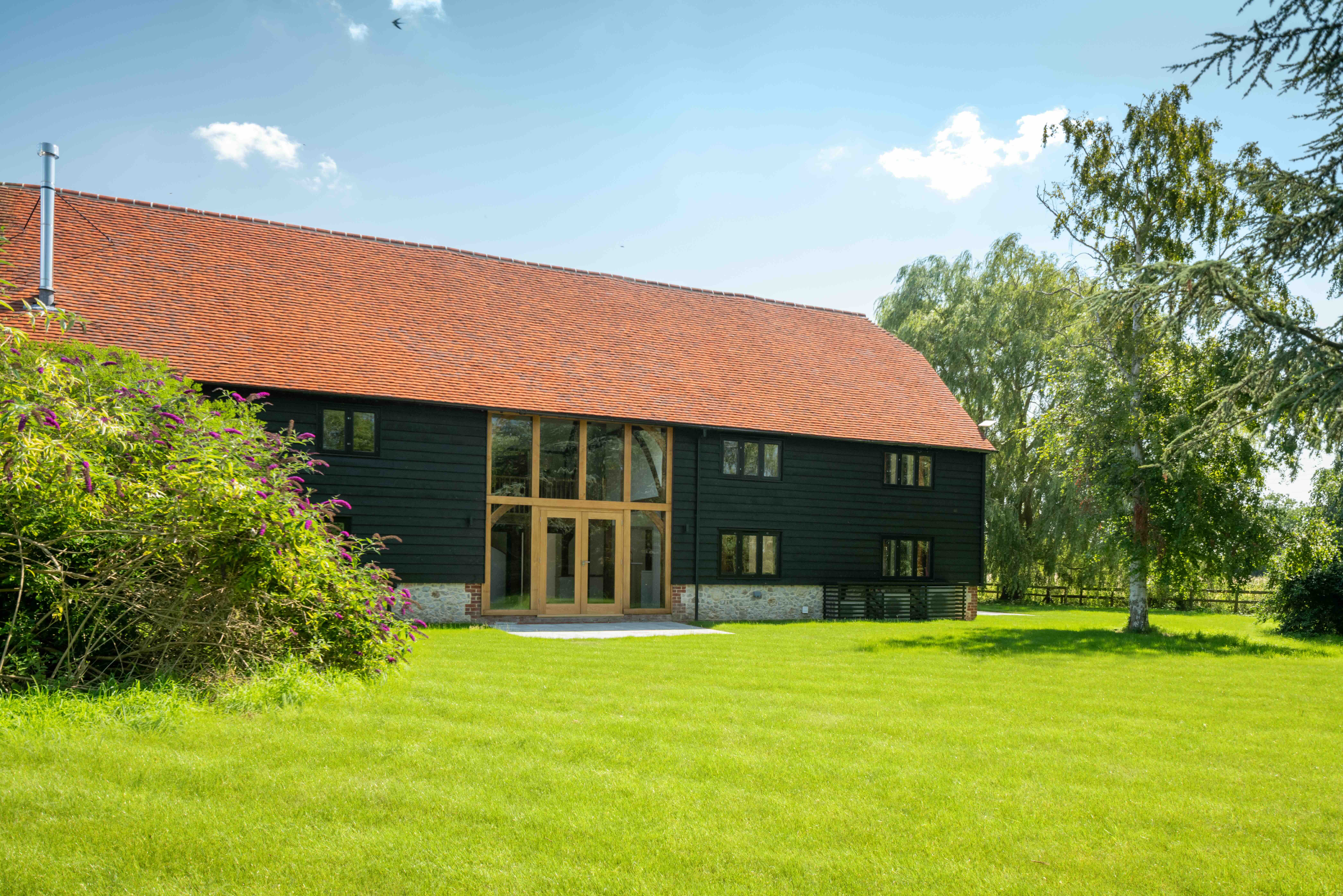    External view of oak-framed barn reconstruction, re-establishing the character of a historic agricultural building in Oxfordshire