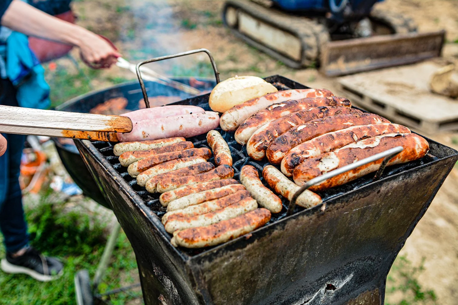 Assorted sausages and seafood grilling on an outdoor barbecue.