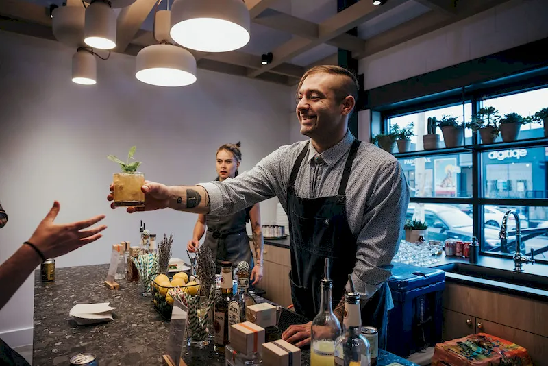 Bartender handing a cocktail to a guest