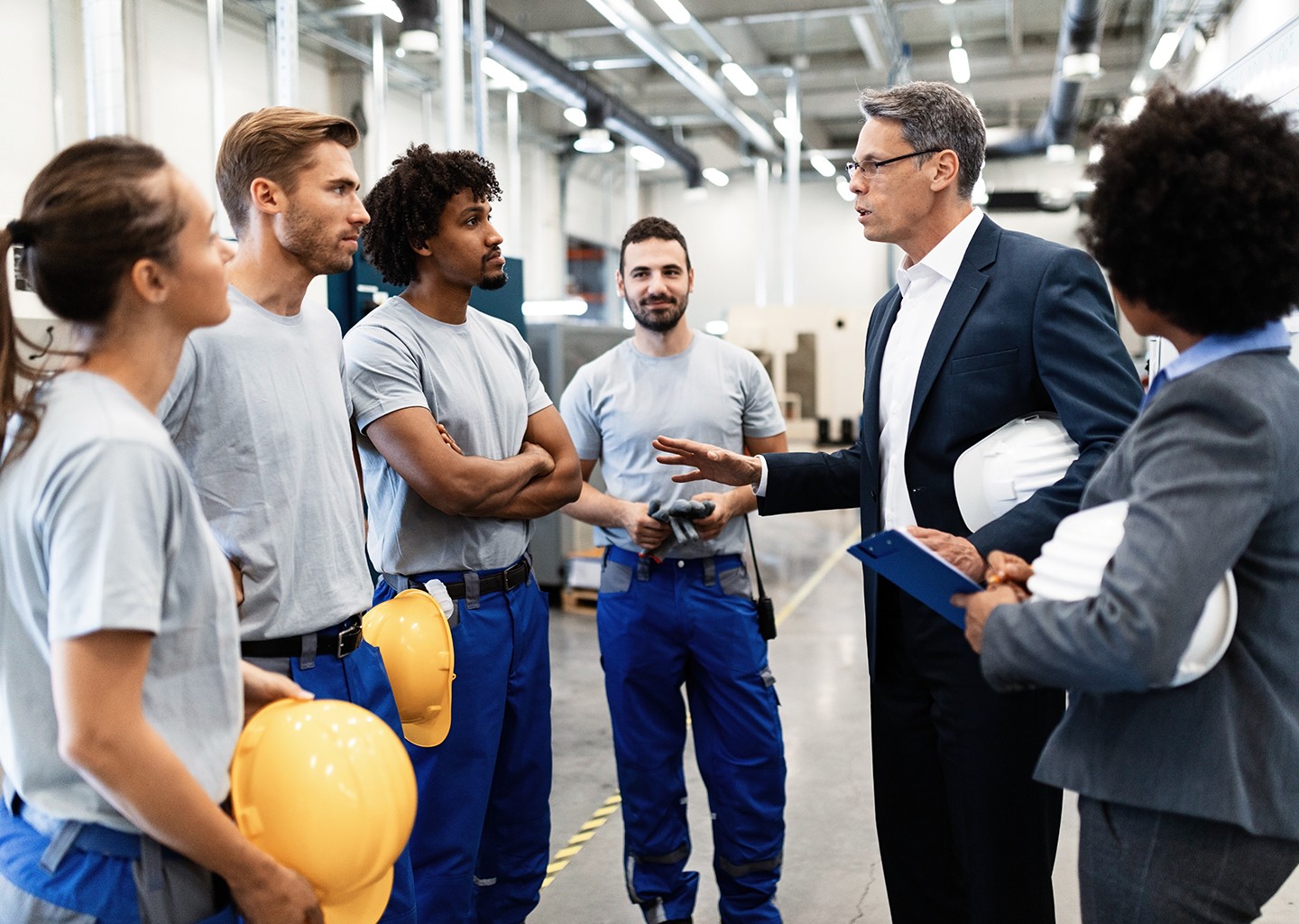 Una squadra di lavoro sta ascoltando un responsabile mentre sta assegnando i turni di lavoro