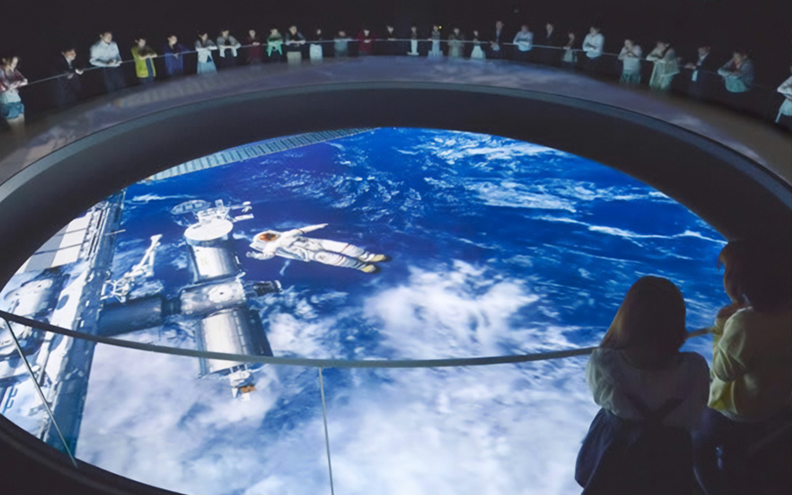 Visitatori che osservano l'esposizione spaziale presso il Museo dello Spazio TeNQ di Tokyo Dome City Attractions.