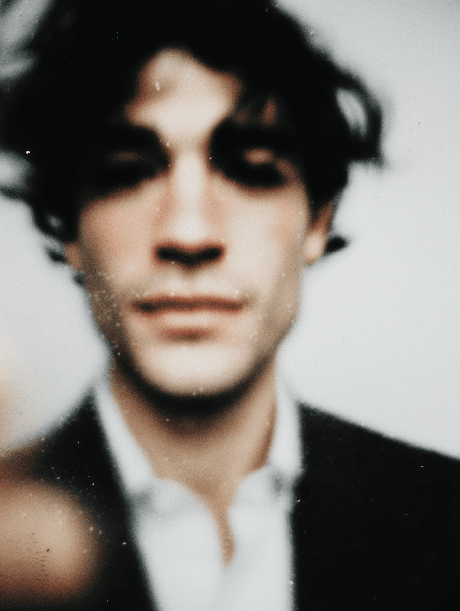 Blurry out-of-focus portrait of a man wearing a dark blazer and white shirt