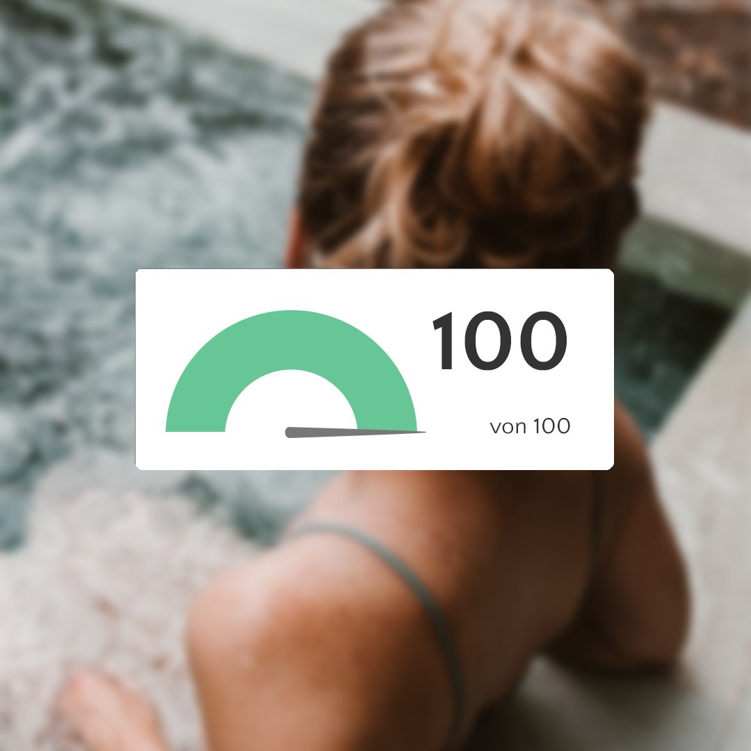 Tacho-Grafik, die auf 100 von 100 steht. Im Hintergrund eine Frau im Whirlpool.