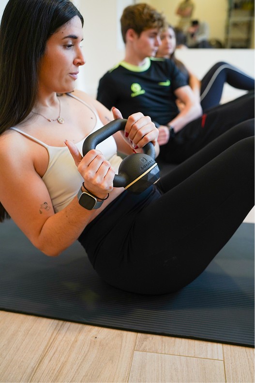 A wooden essential oil diffuser releasing a gentle stream of steam, surrounded by dried herbs and a small bottle of essential oil. The warm lighting enhances the cozy and therapeutic ambiance.