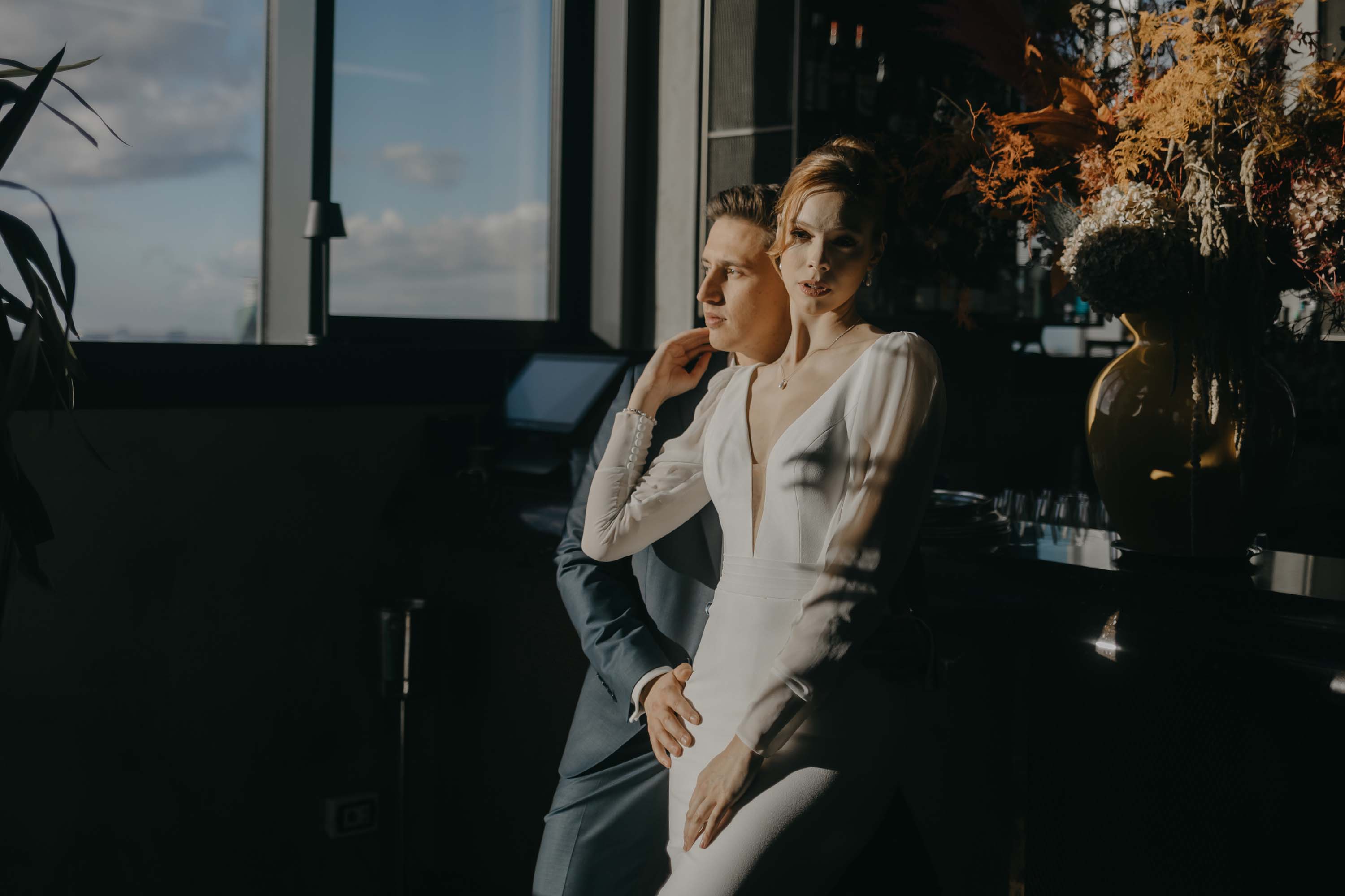 Brautpaar steht eng angelehnt an einer Bar in einem Düsseldorfer Hotel - cool und lässig.