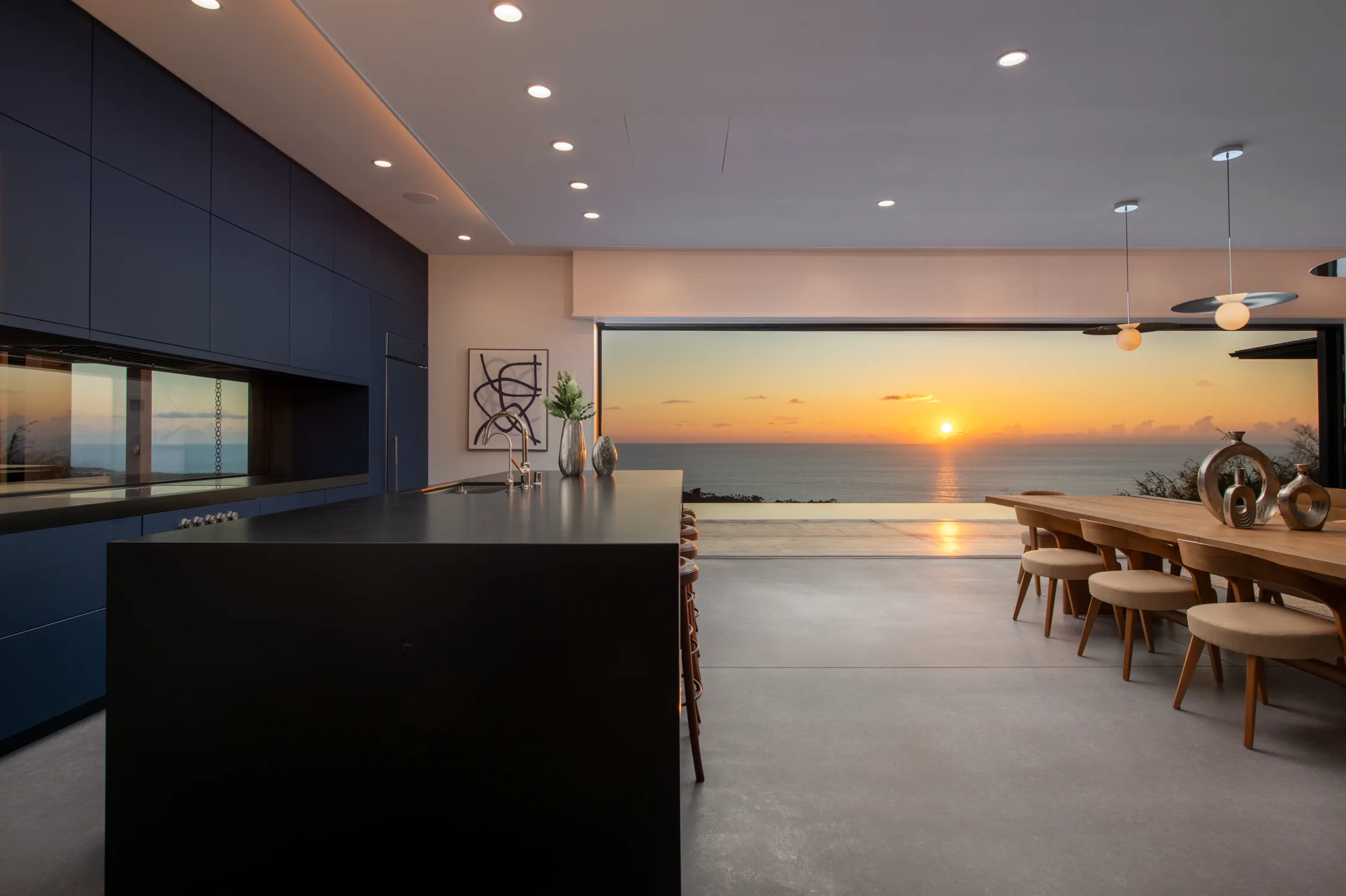 large kitchen interior with black countertop and open space interior, blue cabinets.