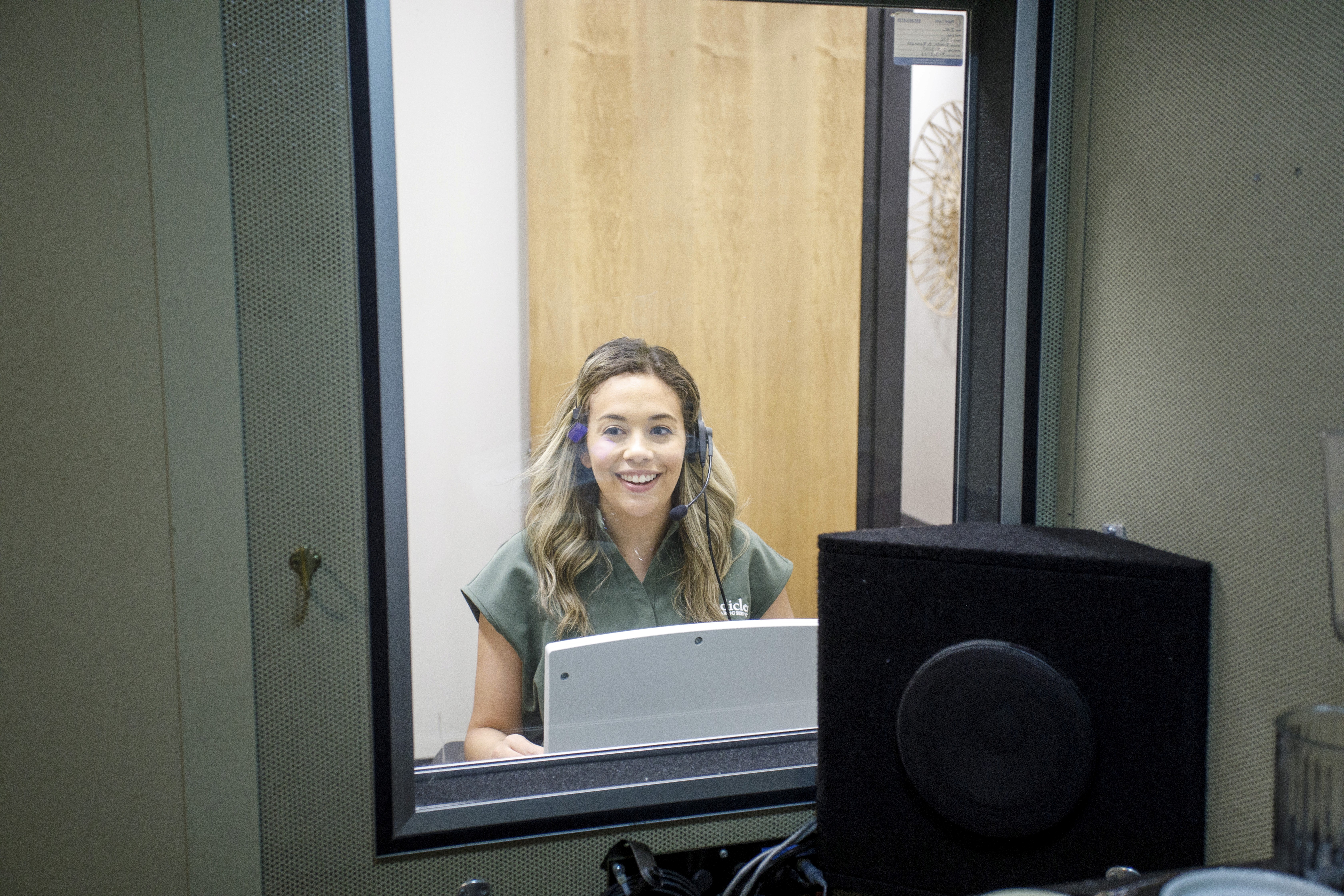 Dr Kelly Garcia testing the hearing of a patient in the testing booth