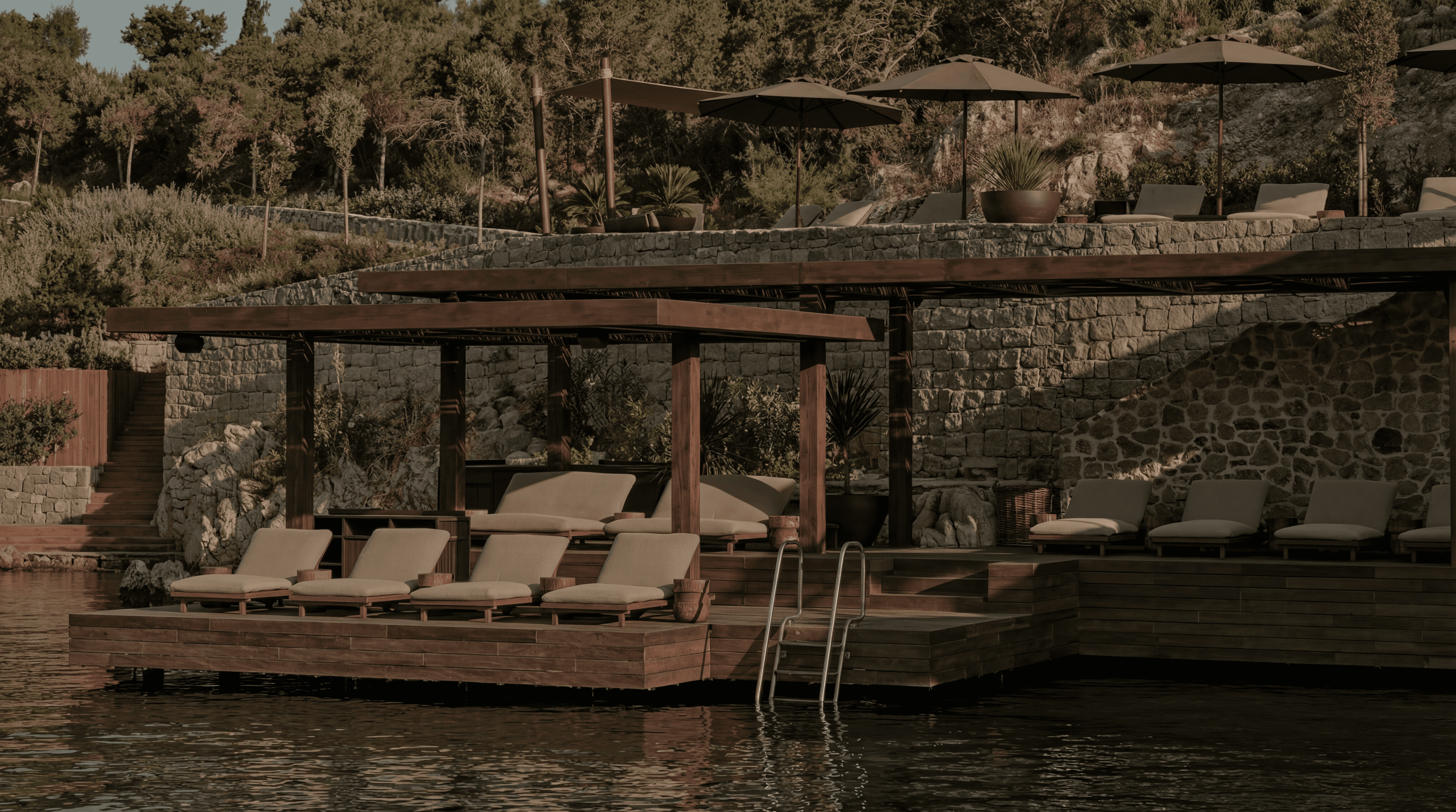 Daybeds and parasols on the waterfront terrace at Scorpios Beach Club Bodrum at golden hour