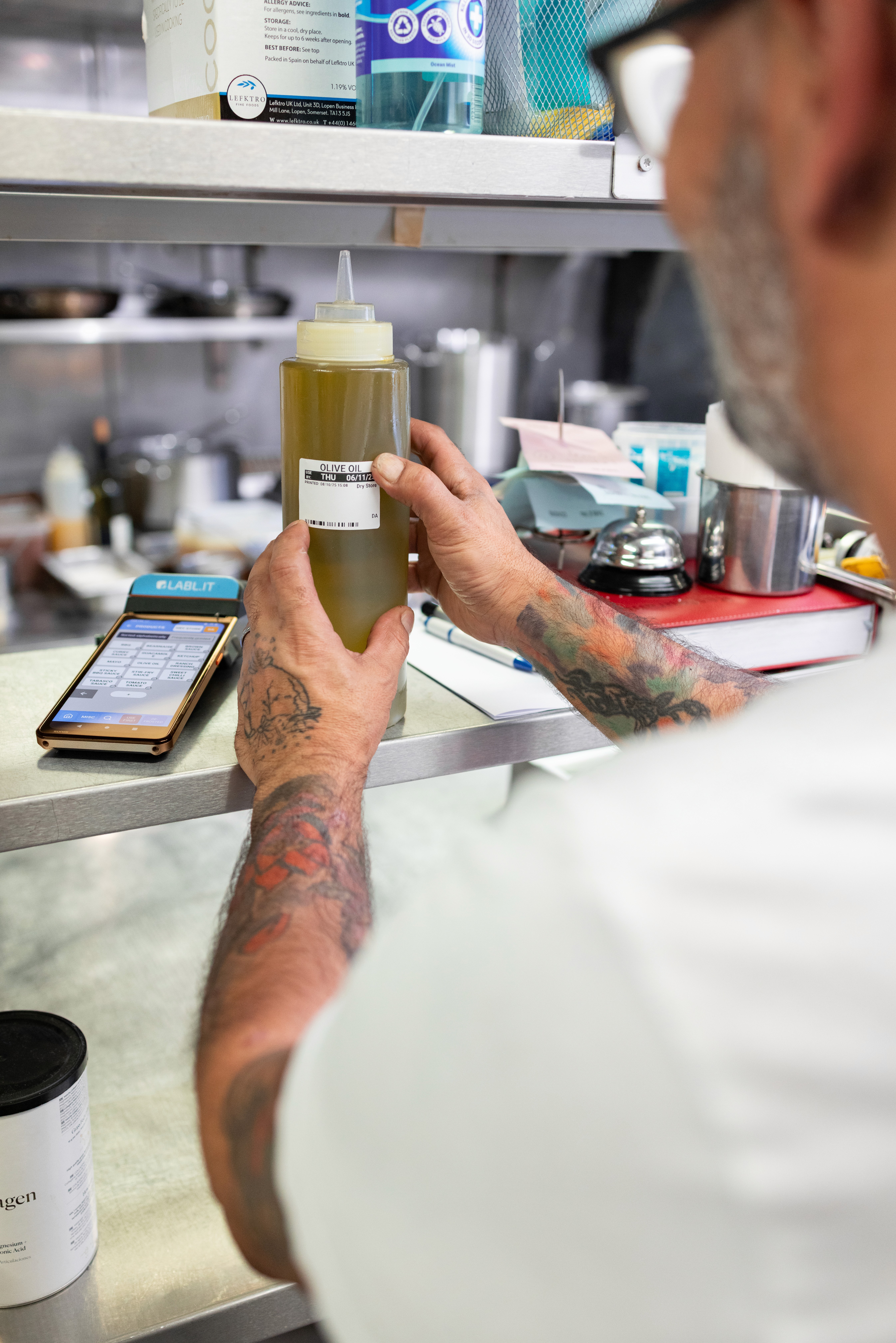chef sticking a label on a bottle of oil