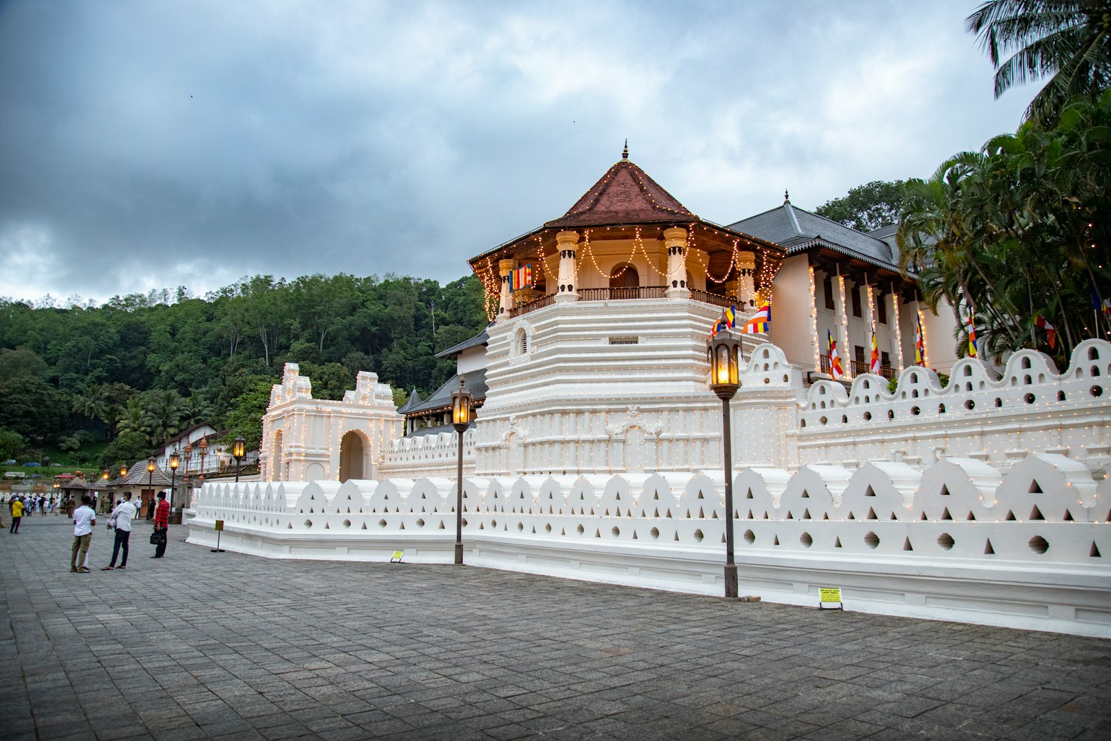 Temple of the Tooth in Kandy under monsoon clouds, supporting the Esala Perahera travel section.