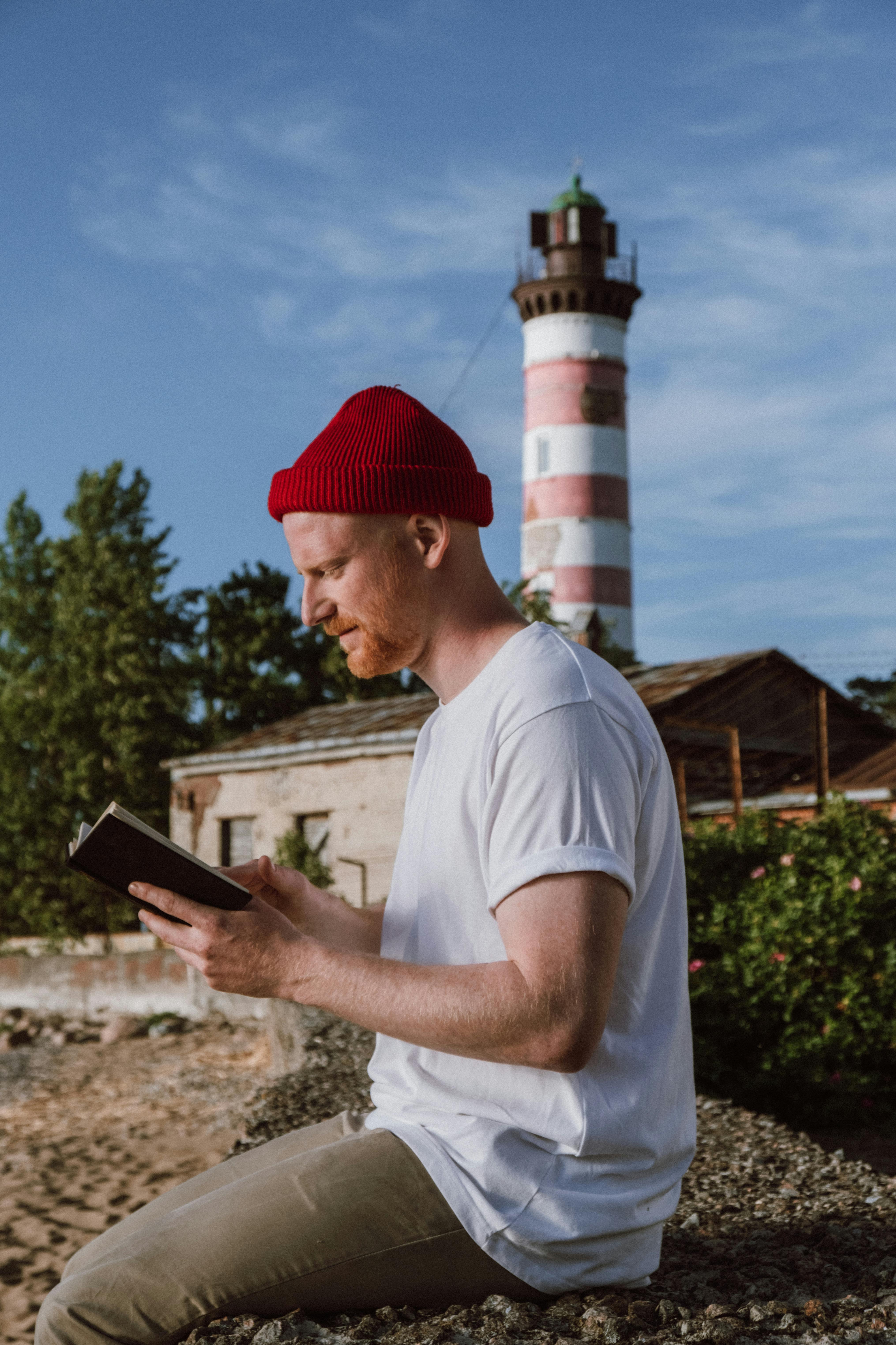 Man reading tablet near lighthouse