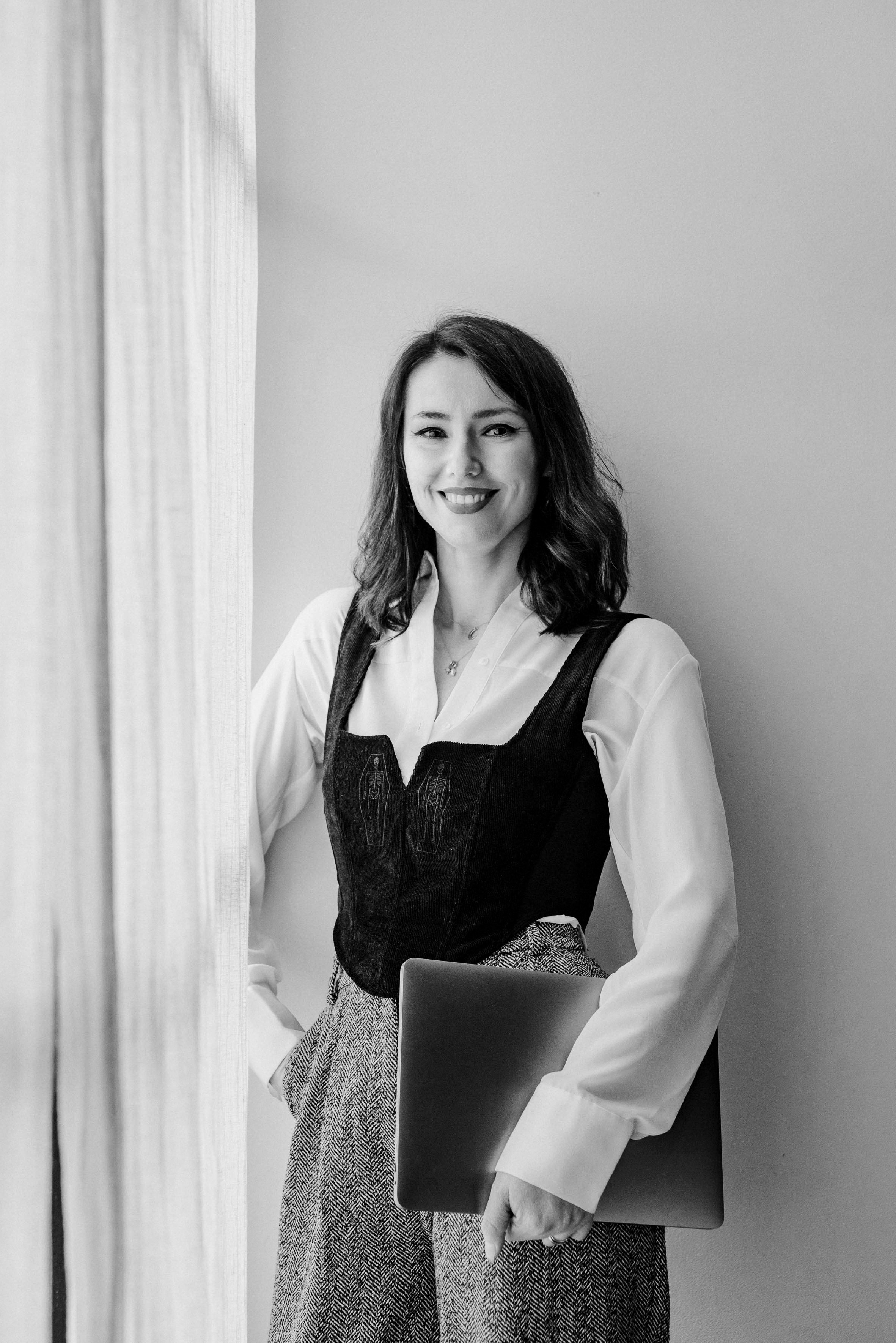 Black and white portrait of a smiling person with curly hair