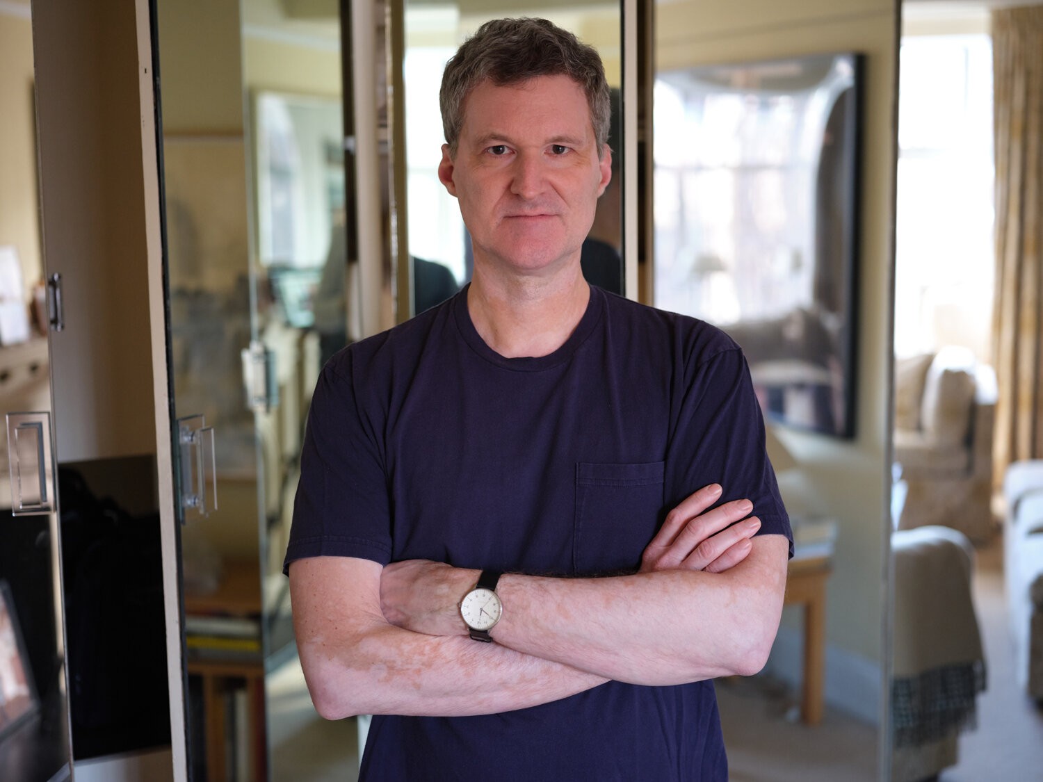 portrait of a man with arms crossed, looking at the camera
