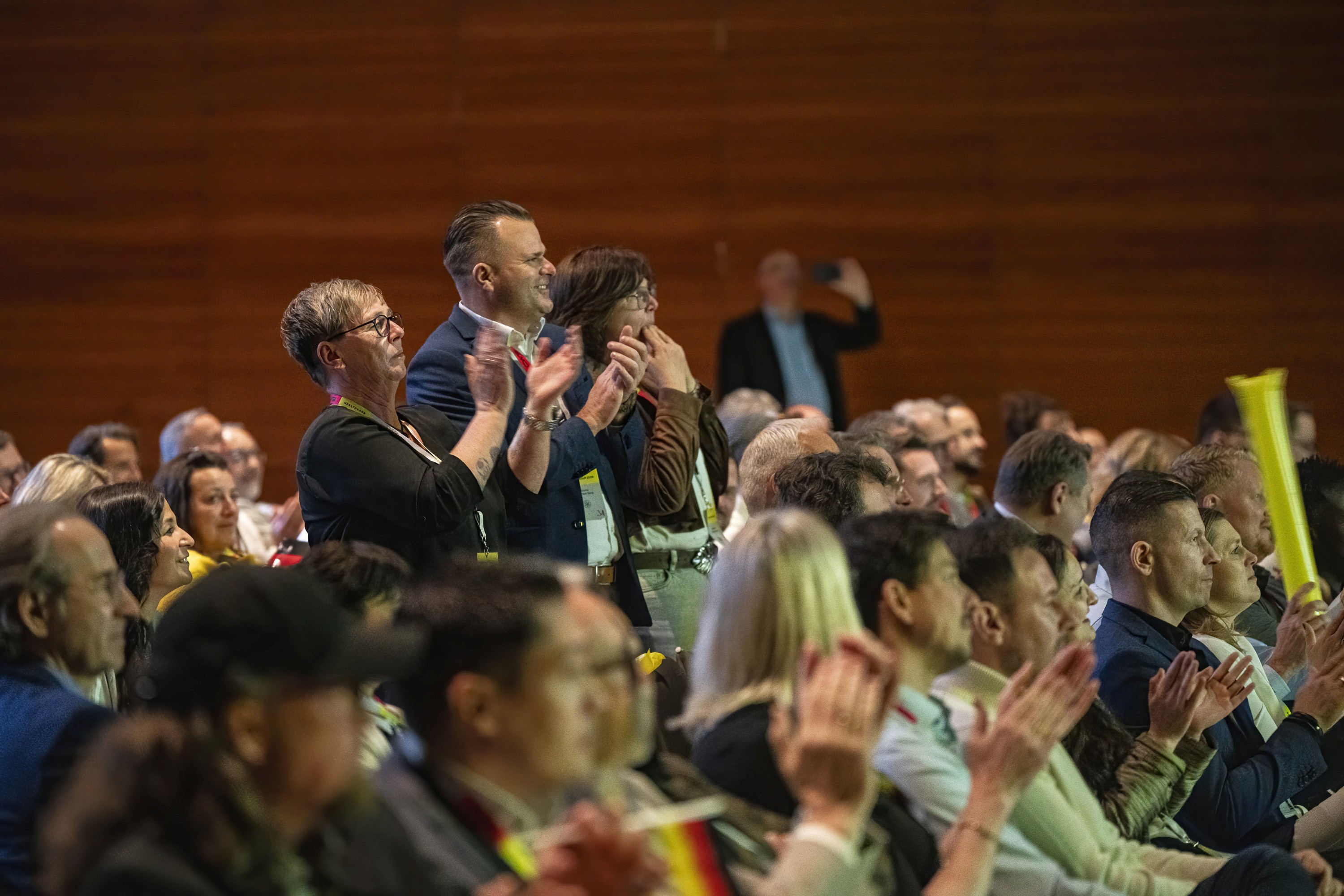 Audience members reacting and applauding during a conference session.