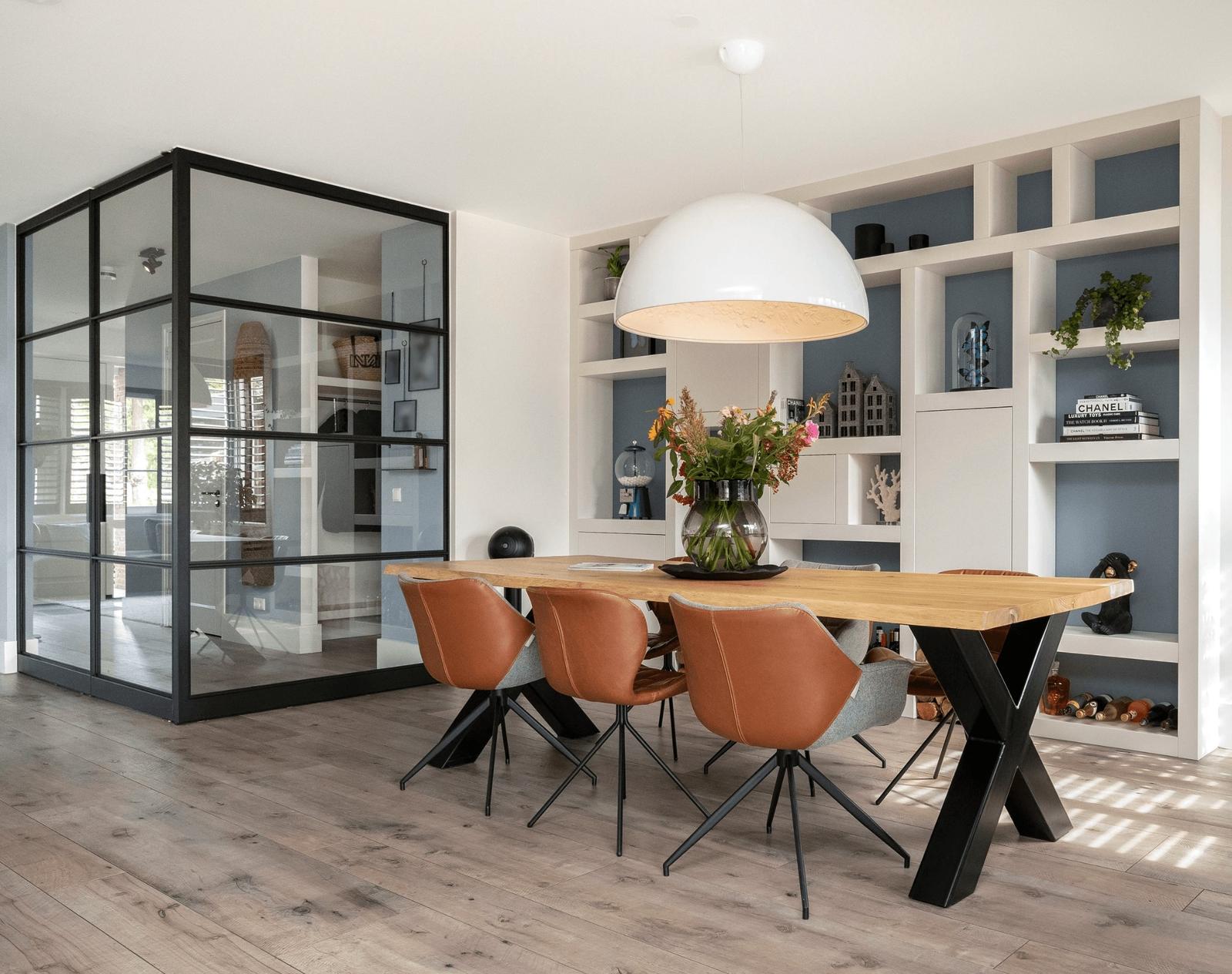 eethoek met grote, maatwerk vakkenkast en hal met stalen pui