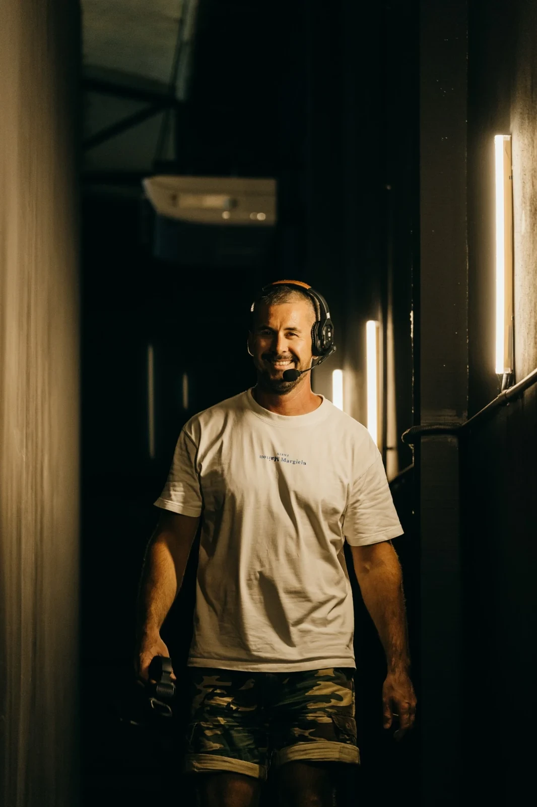 MStudio crew member with a headset walking through the backstage corridor