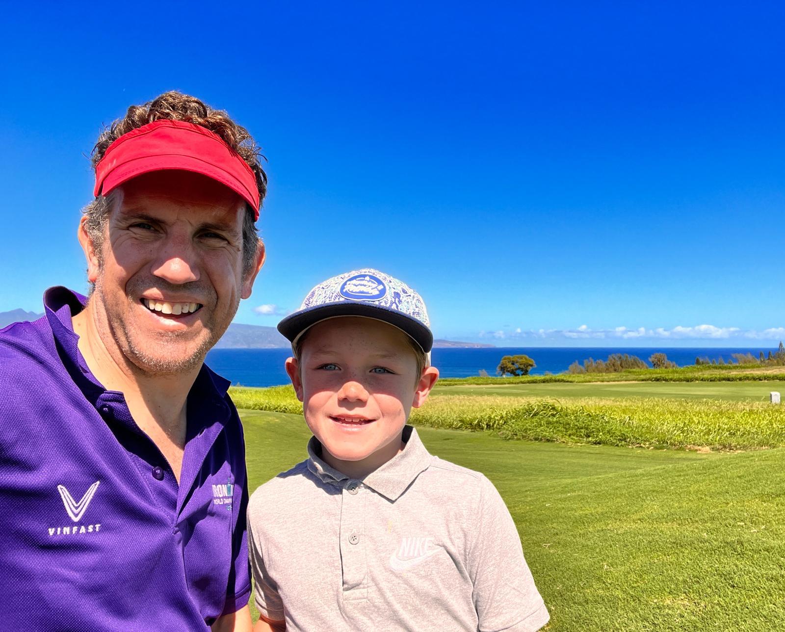 Nev Davies and son smiling together on a golf course beside the sea