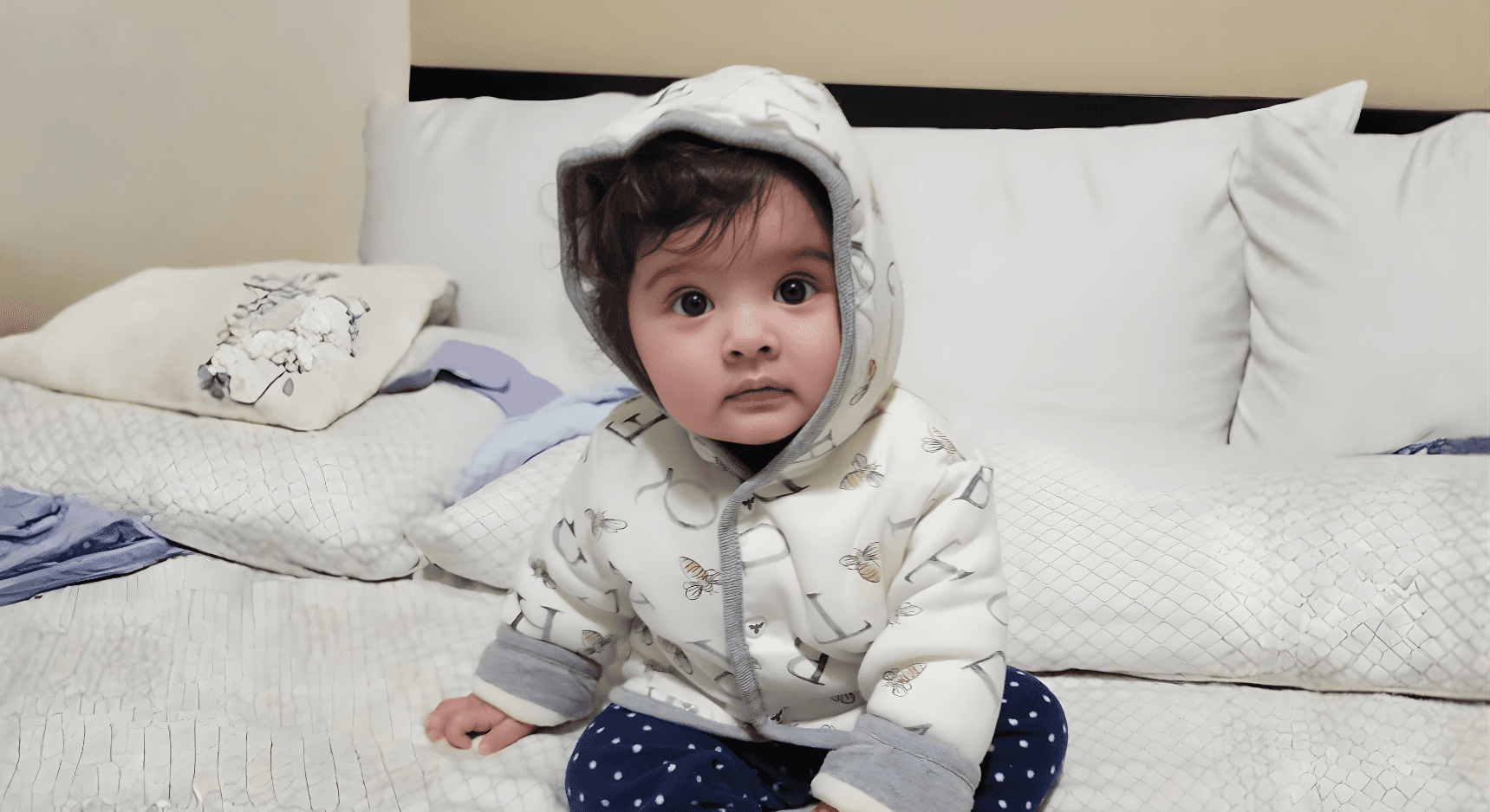 An overhead, rustic photo of a wooden table covered with food, featuring a round pizza cut into quarters, a bowl of French fries, a dish of white cheese slices, and several glasses of water.