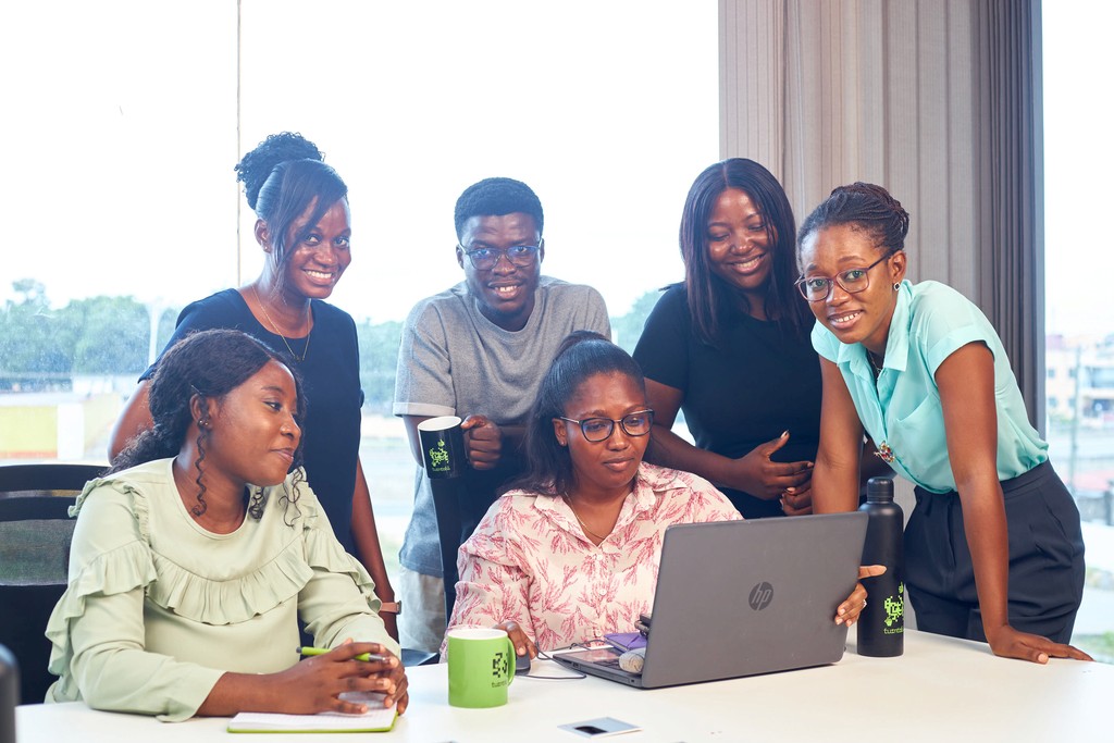 Turntabl team members collaborating around a laptop in a bright, modern office.
