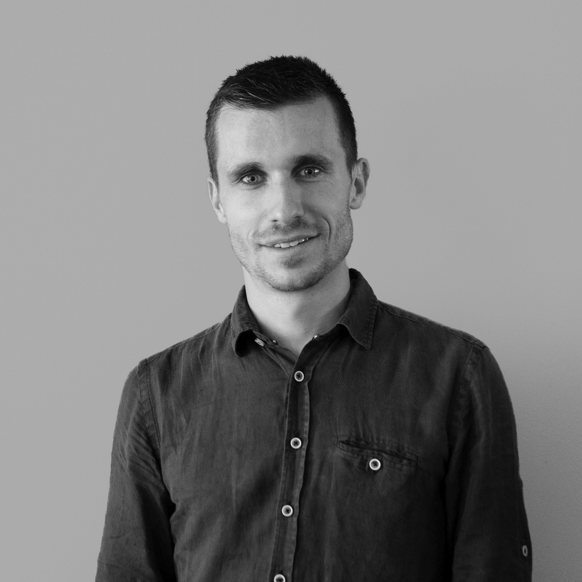 Portrait of a person in a pink sweater against a light background