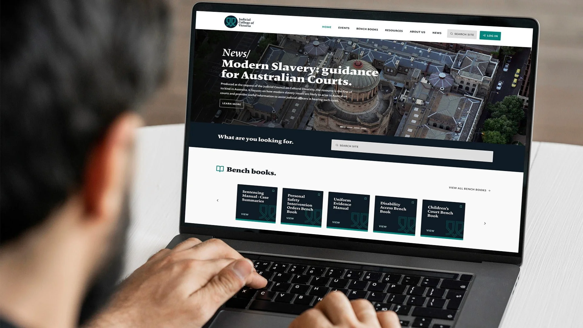 Laptop showing the Judicial College of Victoria site: 'Modern Slavery: guidance for Australian Courts' and Bench books