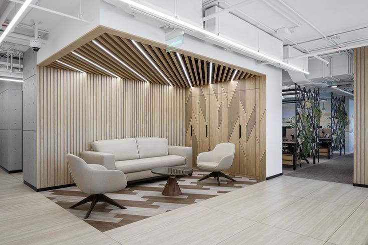 A sophisticated office waiting lounge in Bangalore, a commercial interior project by Zepspace, featuring custom wood slat paneling and integrated ceiling lights