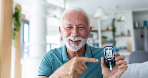  A middle-aged person checking a blood glucose monitor on the console of a parked car, keys visible, natural daylight.