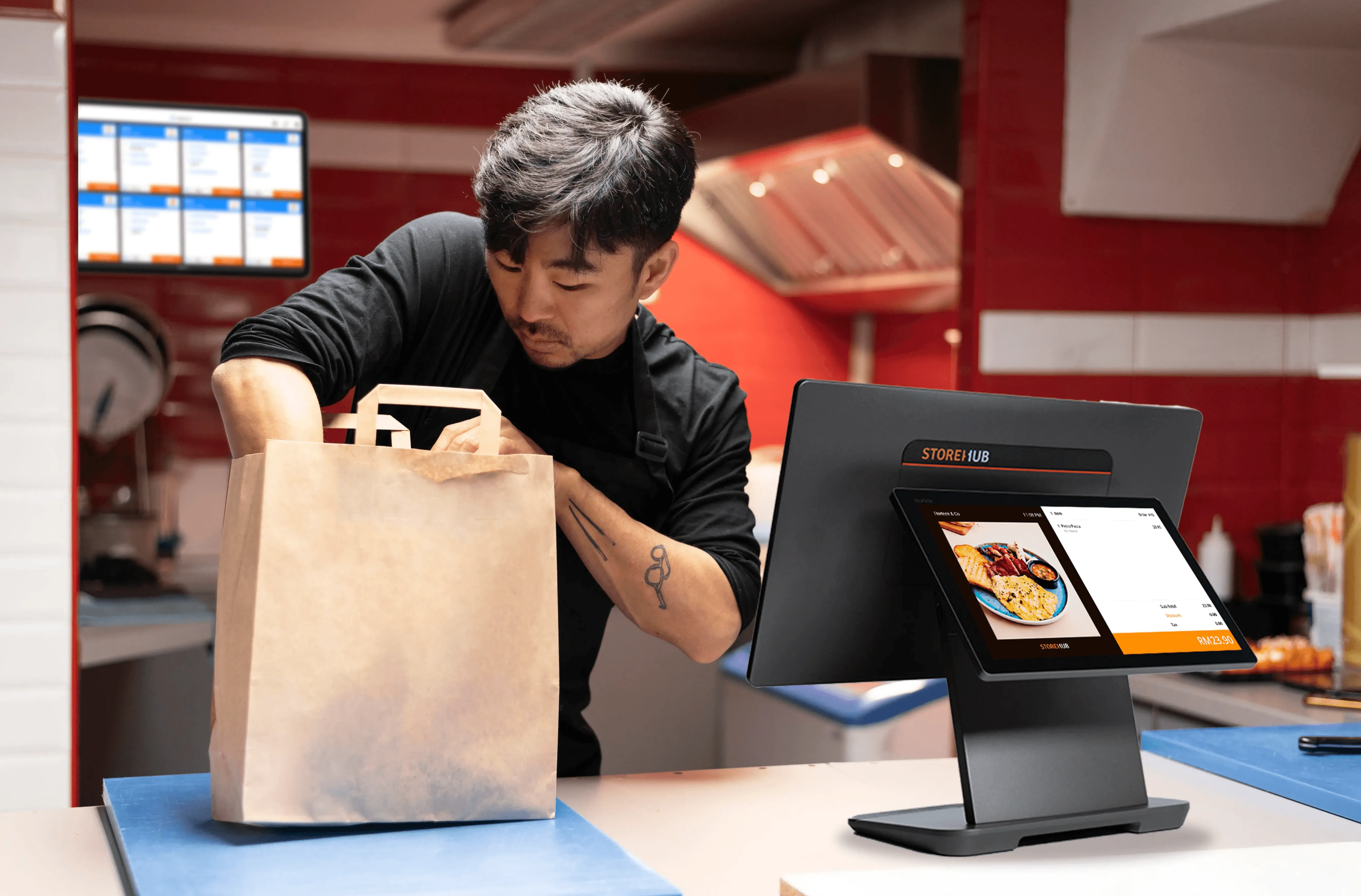 Malaysian quick service restaurant staff packing takeaway, delivery, and pickup orders using the StoreHub cloud POS system.
