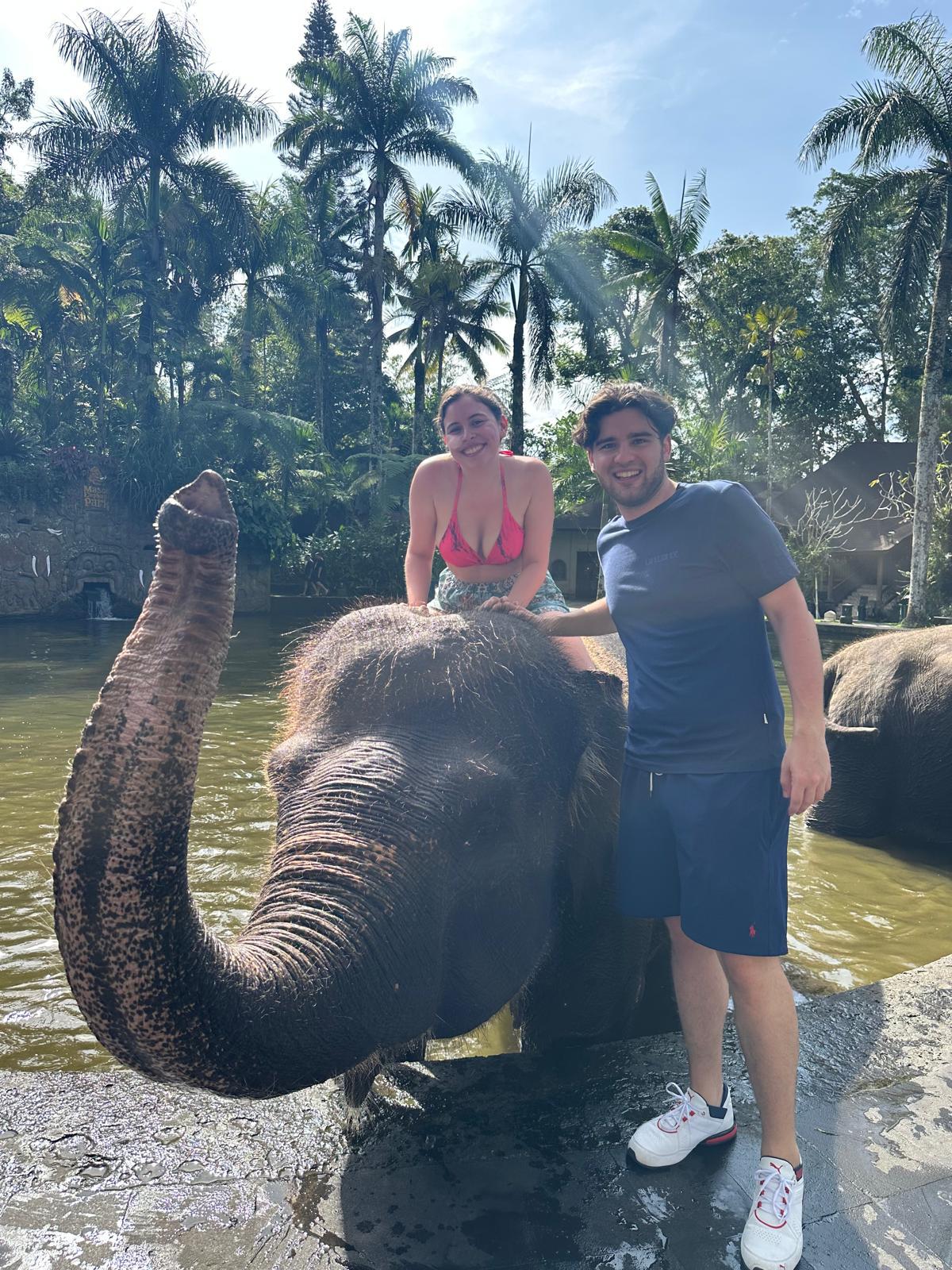 A close-up of two people holding hands, one wearing a denim jacket. The background is softly blurred, suggesting a tender, intimate moment in warm light.