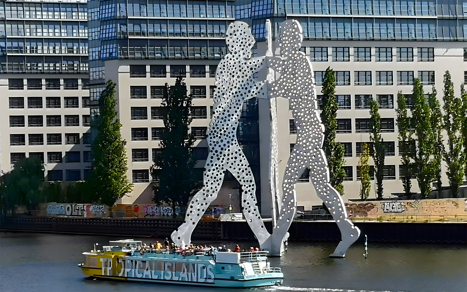 Rejs wycieczkowy mijający rzeźbę Molecule Man na rzece Sprewa we wschodnim Berlinie.