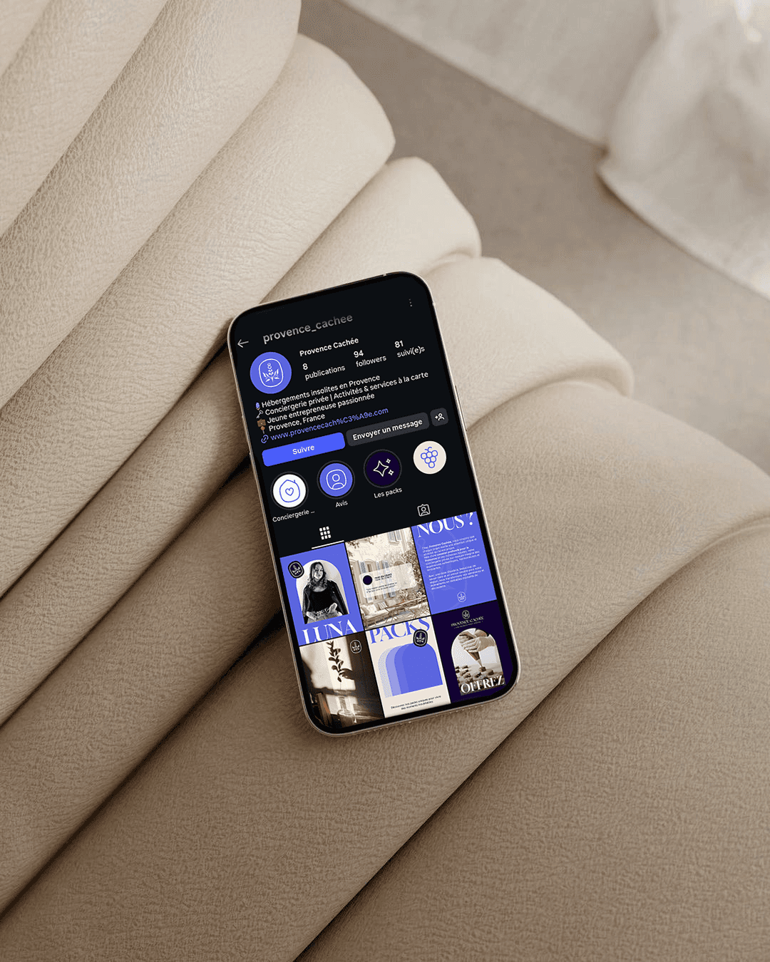 Un téléphone est posé sur un fauteille avec le feed instagram frais et moderne de provence cachée.