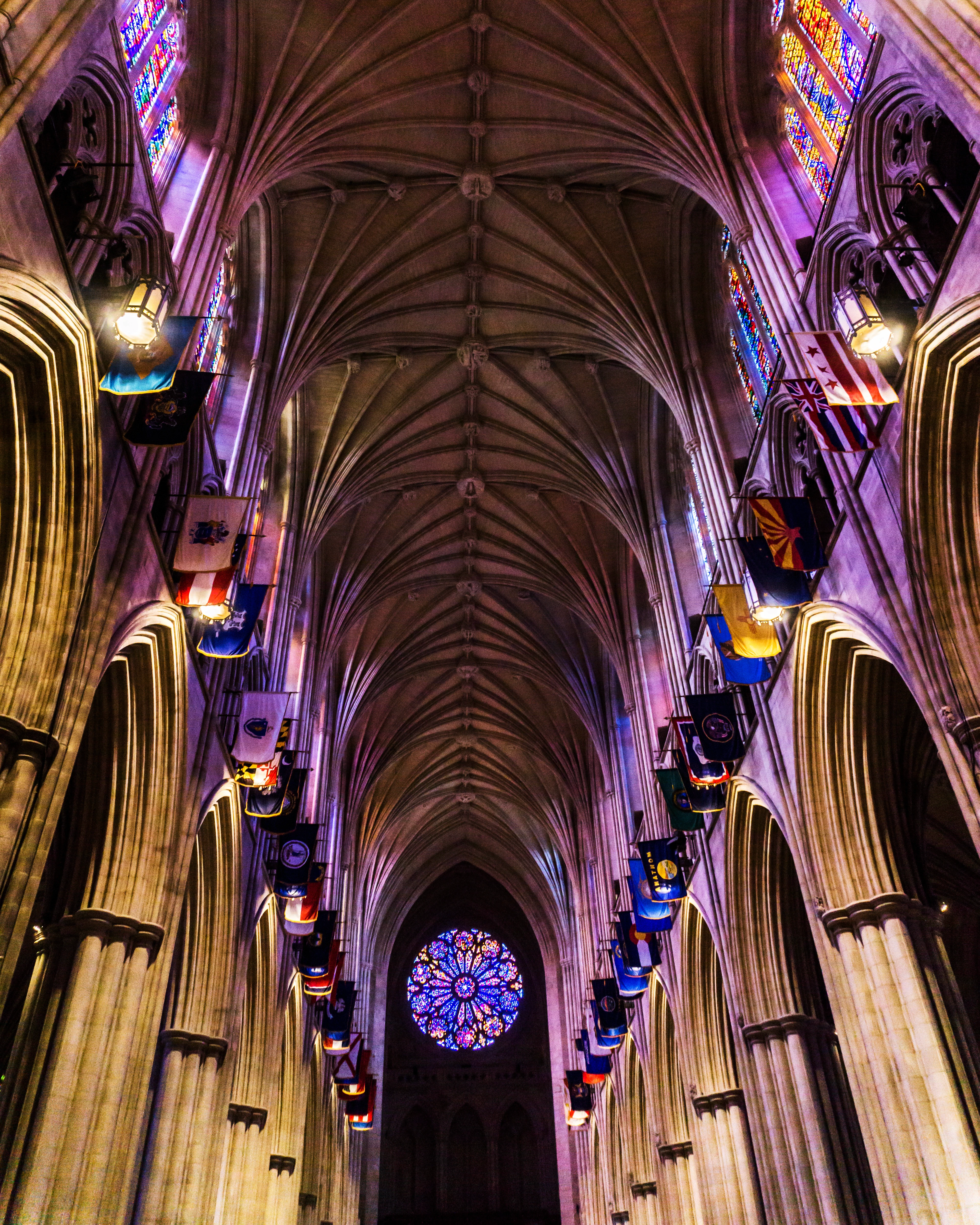 Gothic cathedral interior with vaulted ceiling, stained-glass windows and heraldic flags, reference imagery for Monduke's visual identity by Sebastian Saavedra