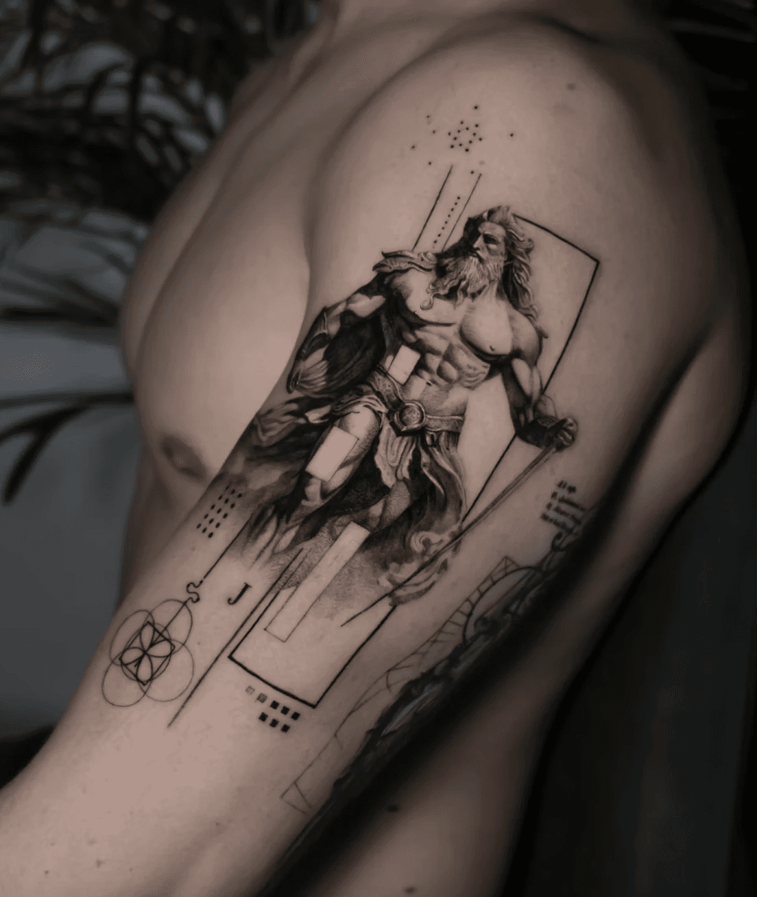 Mythological arm tattoo of Zeus with artistic shading.